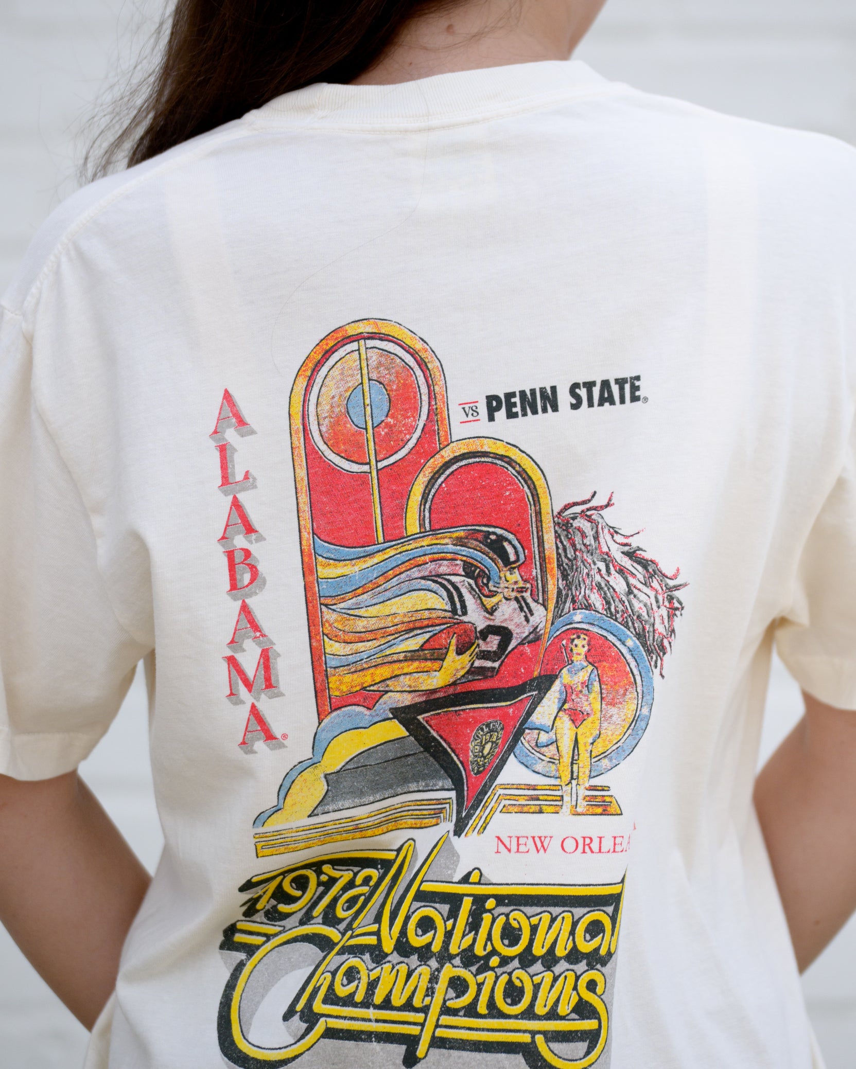 University of Alabama 1978 National Champions Comfort Colors  Ivory T- Shirt with an image of a football player running with a football and a color guard woman and yellow retro neon sign style text "1978 National Champions"