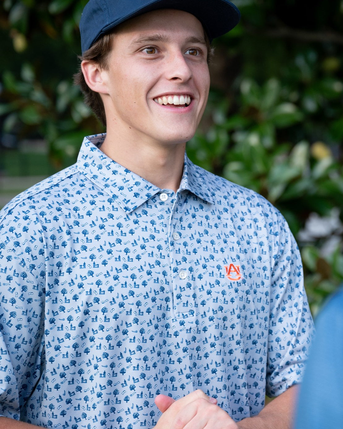 Auburn University Blue Men's Polo with a pattern of Toomers Corner Icons, and an embroidered Orange AU Logo