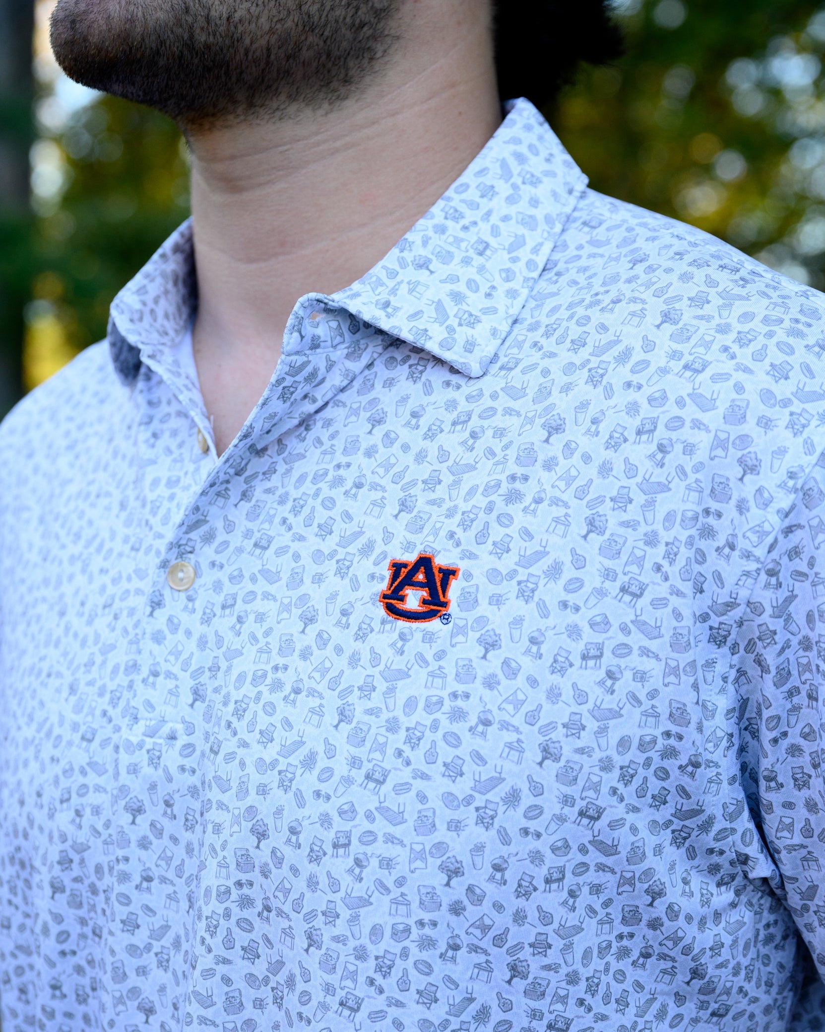 Auburn University AU Tailgate Polo (AU Logo) Grey Men's JNJ Performance Polo with a small Grey pattern of Drinks, Snacks, Grills, and Alabama states, etc.. and AU Logo Embroidery