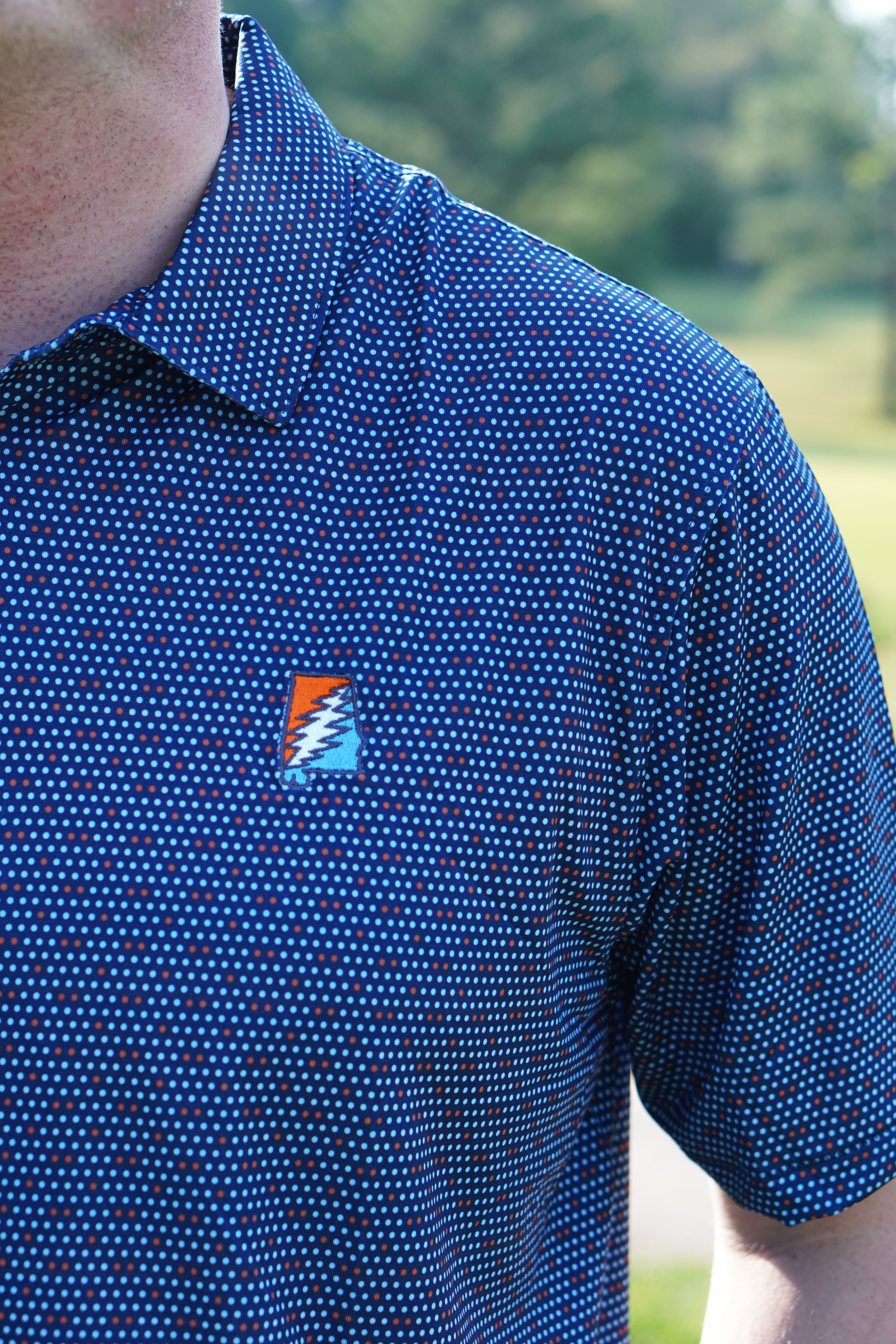 Auburn University AU Team Dot Polo (Grateful State) Navy Men's JNJ Performance Polo  with a pattern of Light Blue and Orange Dots and Embroidered Orange and Blue Grateful State Logo