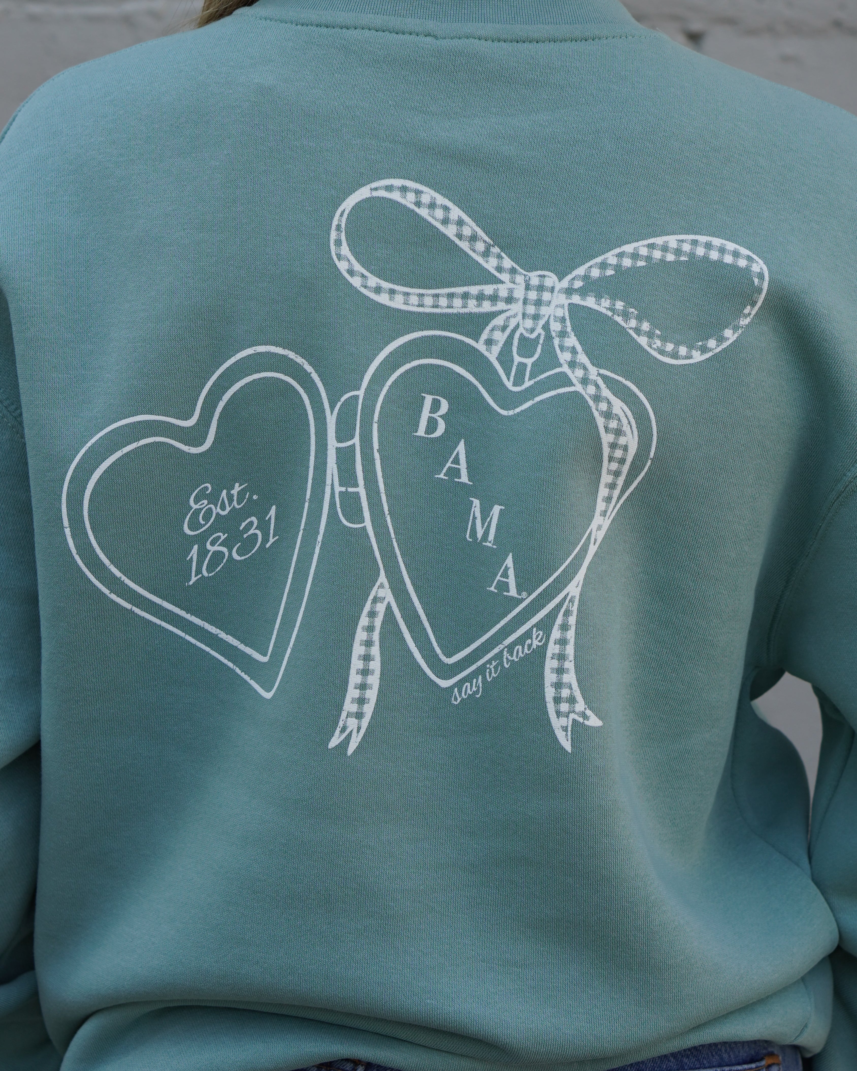University of Alabama Seafoam Crewneck with cursive writing on the front and an open locket with the writing “Bama” inside on the back