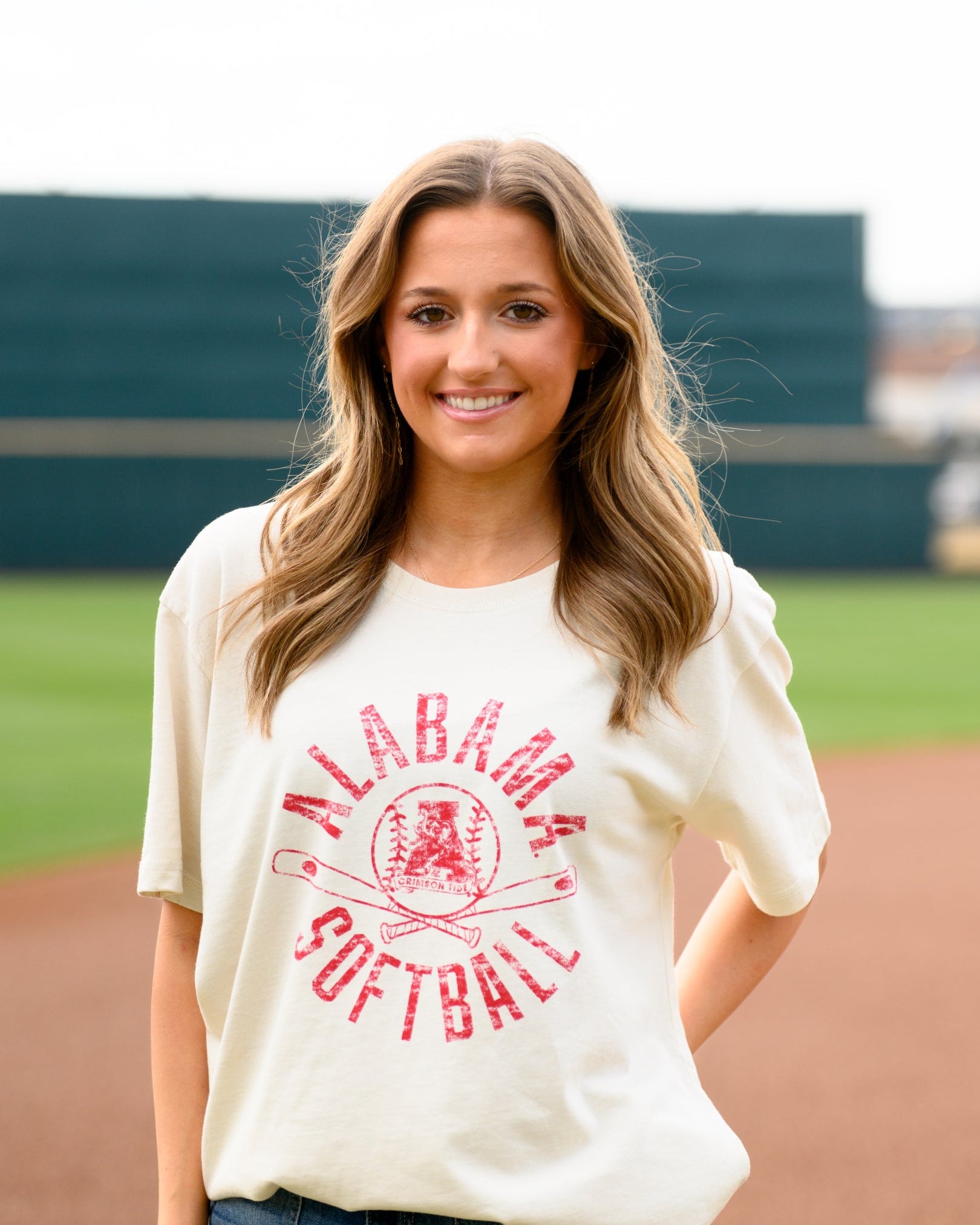 University of Alabama Distressed Ivory T-Shirt with a Red Softball featuring the Vintage A logo over crossed Softball bats, surrounded by Red text “Alabama Softball”