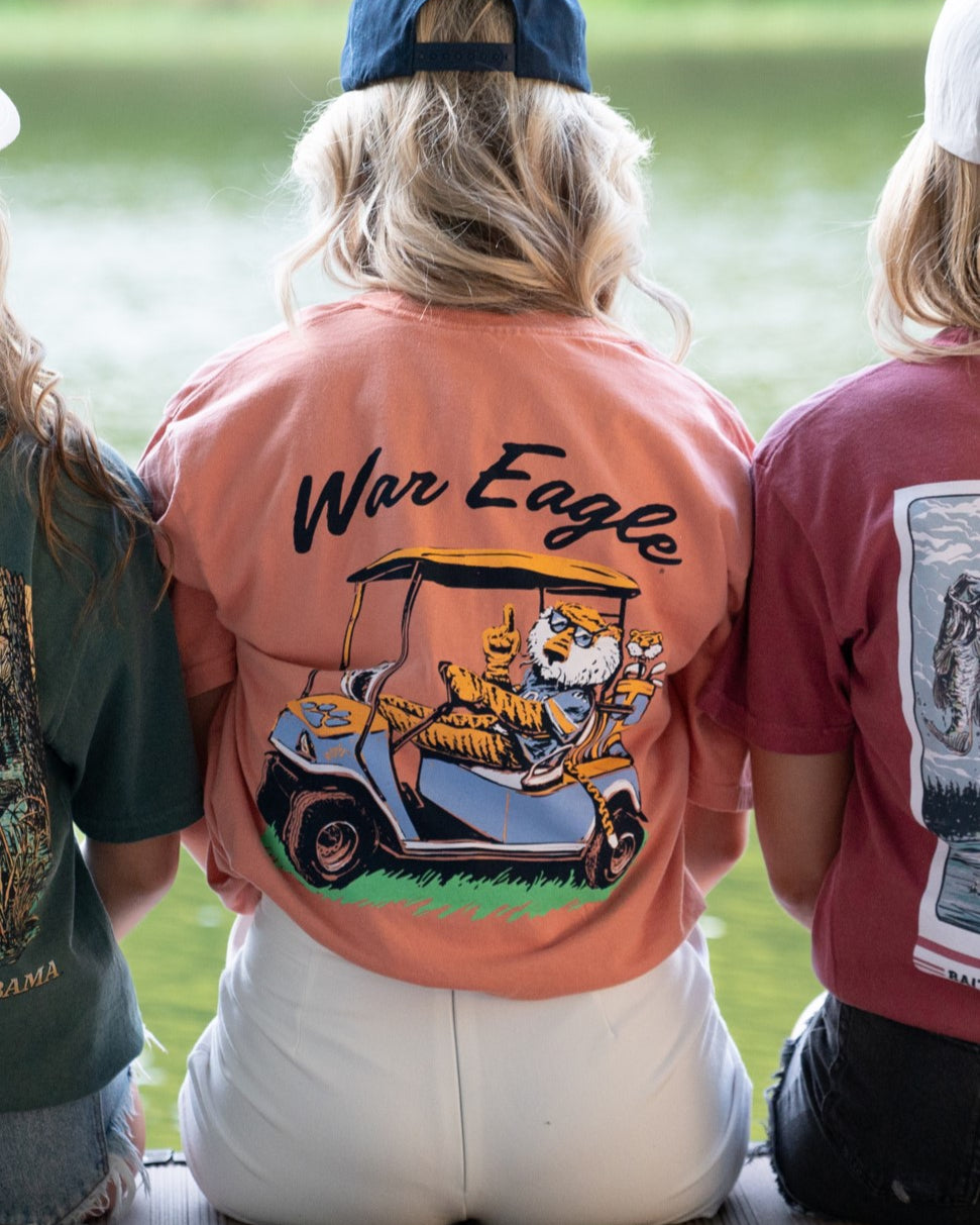 Auburn University Aubie Golf Cart Terracotta Comfort Colors T-Shirt  with the text "War Eagle" above an image of Aubie the Tiger wearing sunglasses and driving a golf cart