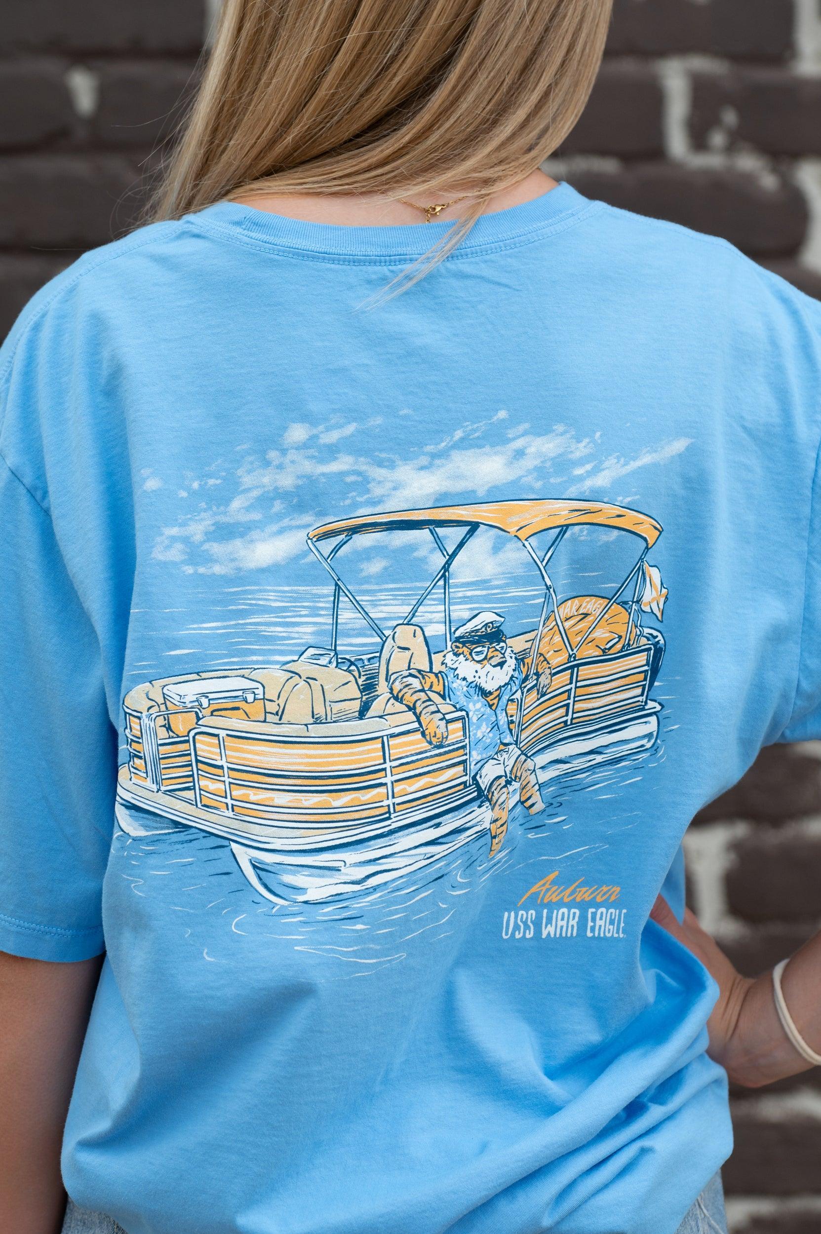 Auburn University Aubie Pontoon Azure Comfort Colors T-Shirt with an image of Aubie the Tiger lounging on the side of an Orange and White Pontoon Boat with the text "USS WAR EAGLE" below