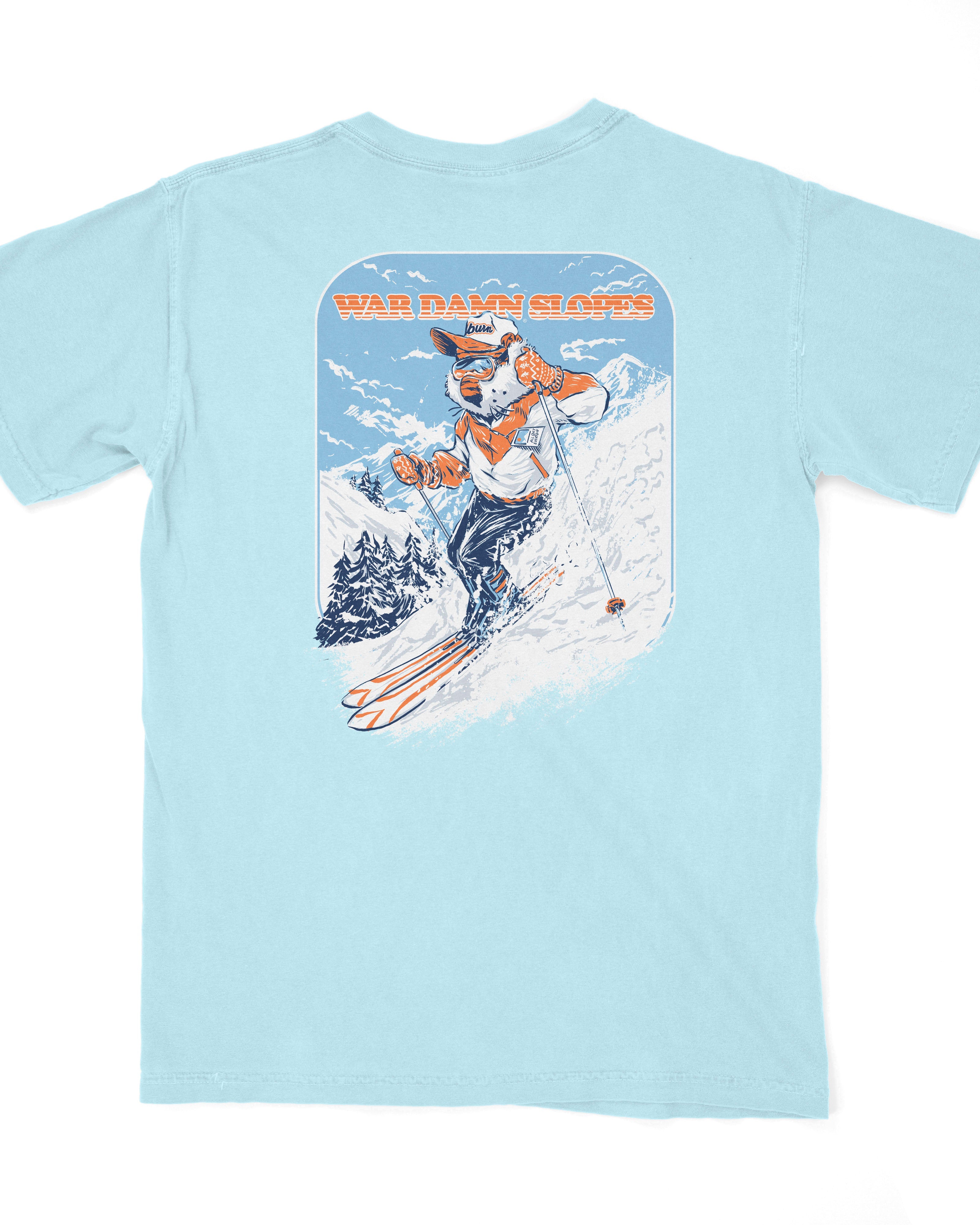 Auburn University Aubie Snow Skiing Chambray Comfort Colors T-Shirt with text "War Damn Slopes" above an image of Aubie in a ski outfit skiing down a snow-covered mountain