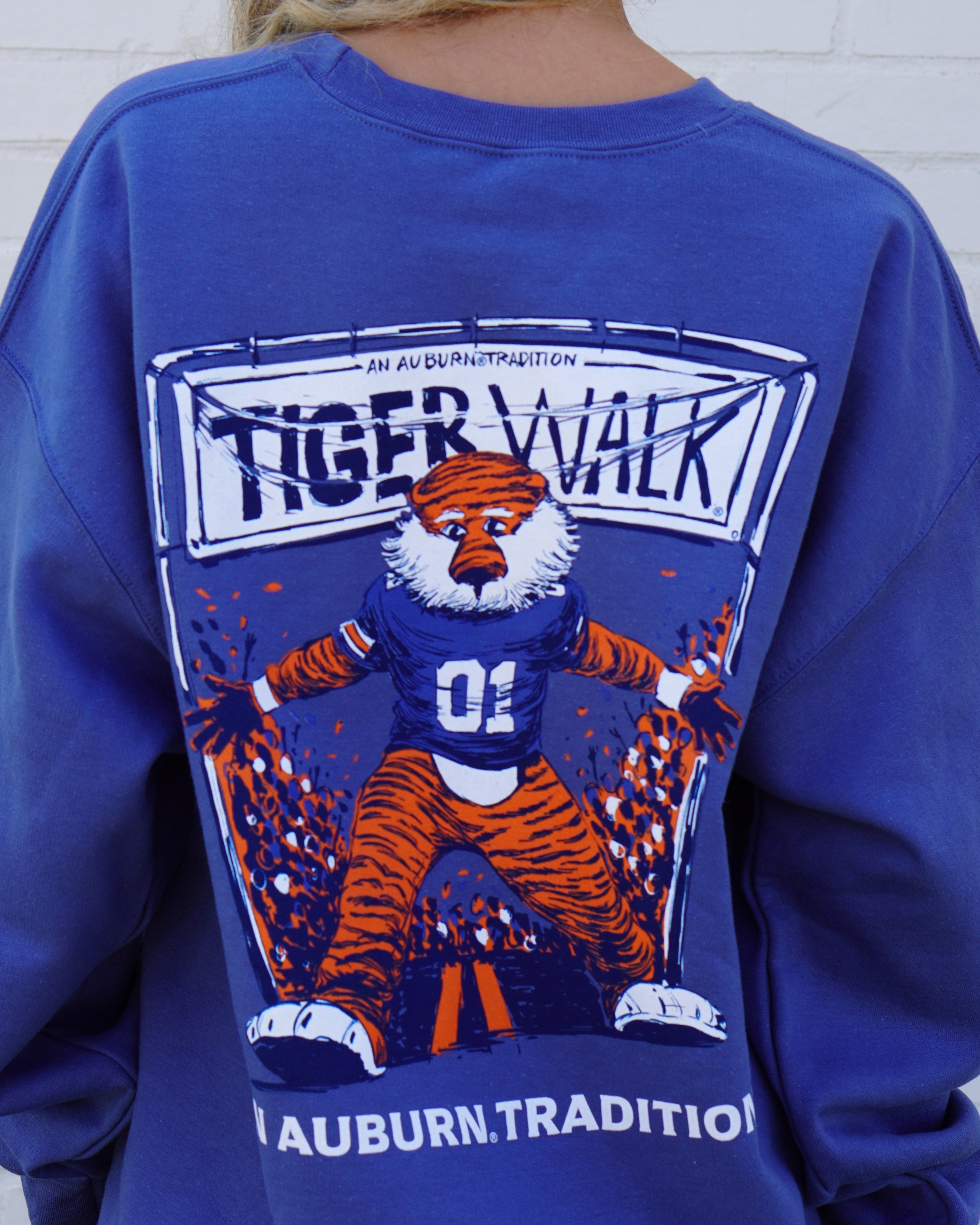 Auburn University Aubie Tiger Walk Indigo Blue Gildan Sweatshirt with an image of Aubie the Tiger leading a parade under a banner with the text "Tiger Walk"