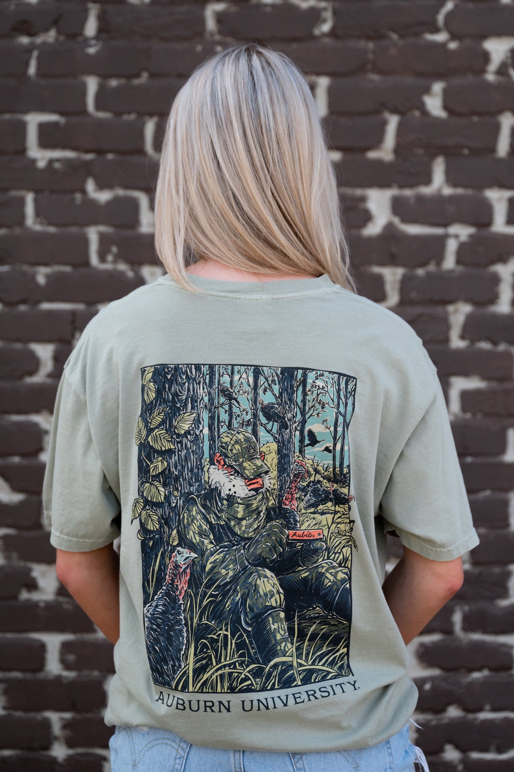 Auburn University Aubie Turkey Call Comfort Colors Bay with an image of Aubie the Tiger wearing hunting gear and sitting next to turkeys