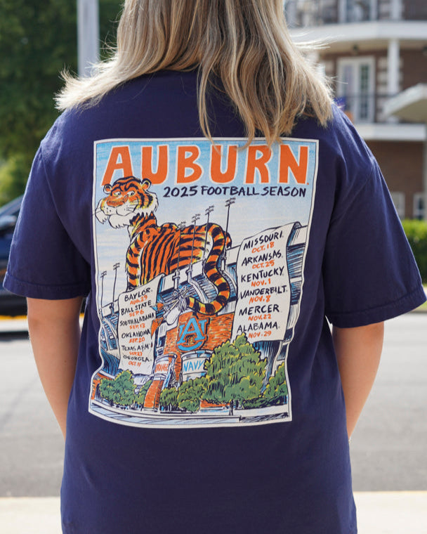 Auburn University Navy T-Shirt with an image of Aubie laying on the stadium and painting the Auburn football schedule on two banners