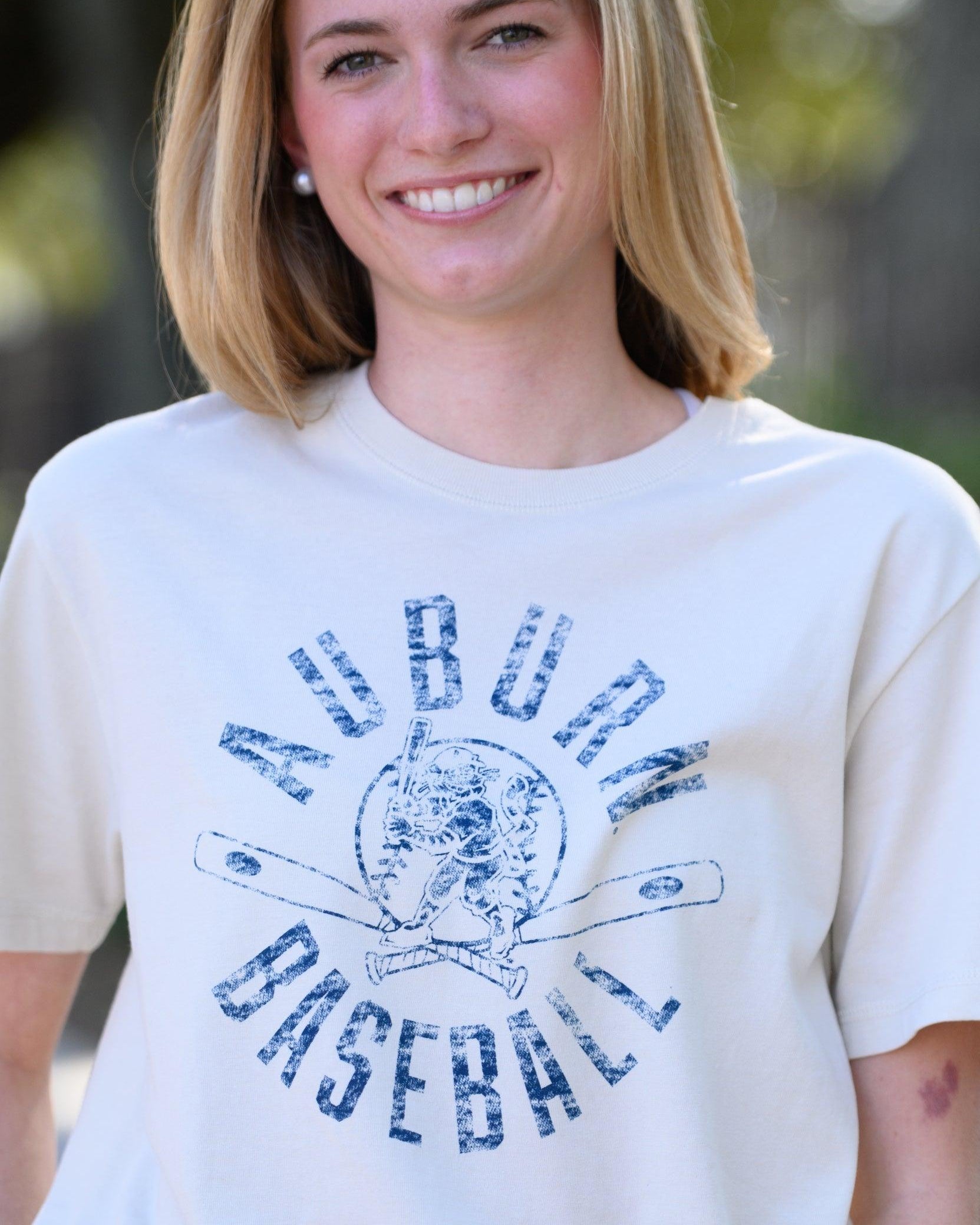Auburn University Distressed Ivory with a Blue Baseball featuring the Original Aubie Baseball logo over crossed baseball bats, surrounded by Blue text “Auburn Baseball”