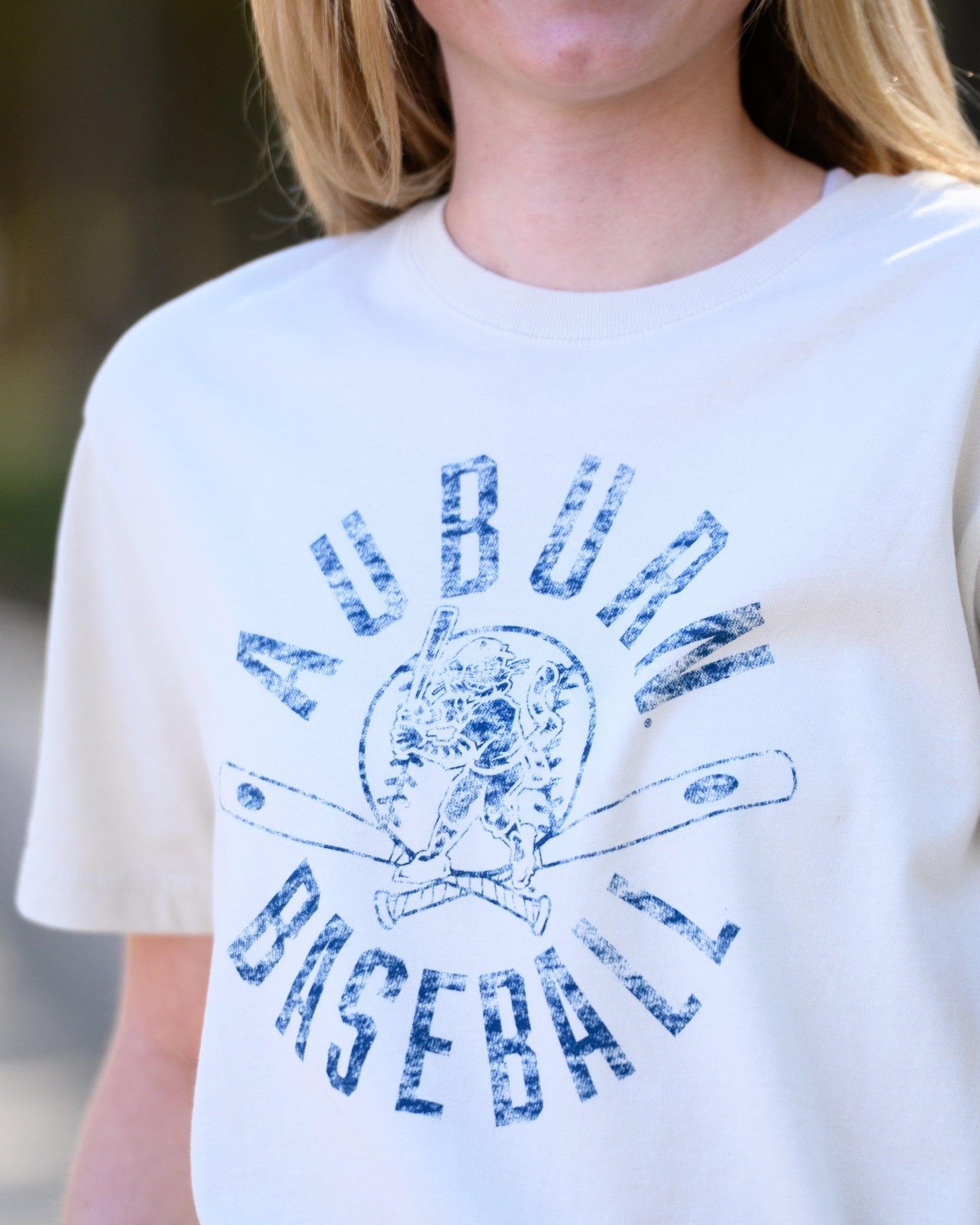 Auburn University Distressed Ivory with a Blue Baseball featuring the Original Aubie Baseball logo over crossed baseball bats, surrounded by Blue text “Auburn Baseball”