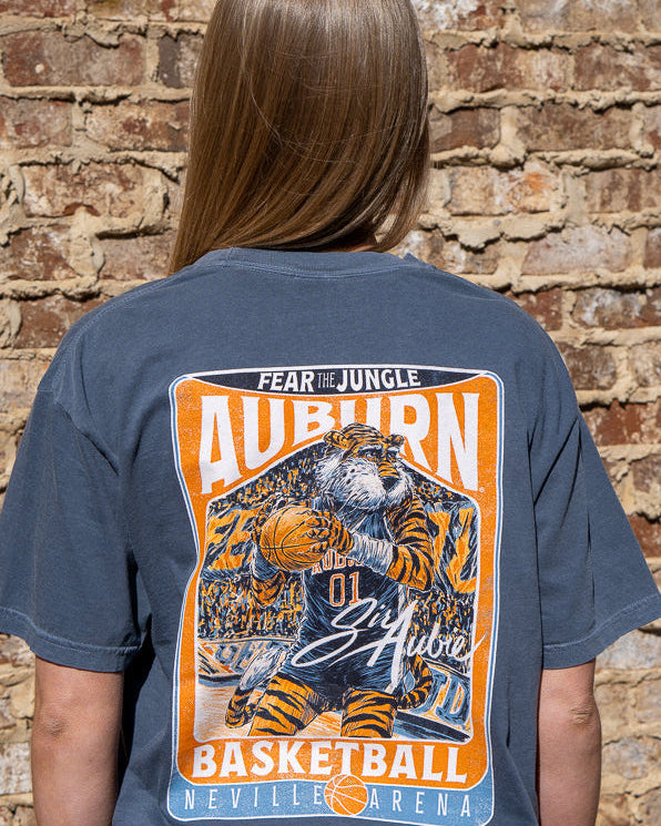 Auburn University Dark Blue T-Shirt with a basketball card style design featuring Aubie dribbling a basketball down the court in between text “Fear the Jungle Auburn” and “Basketball Neville Arena” and with an autograph from “Sir Aubie”
