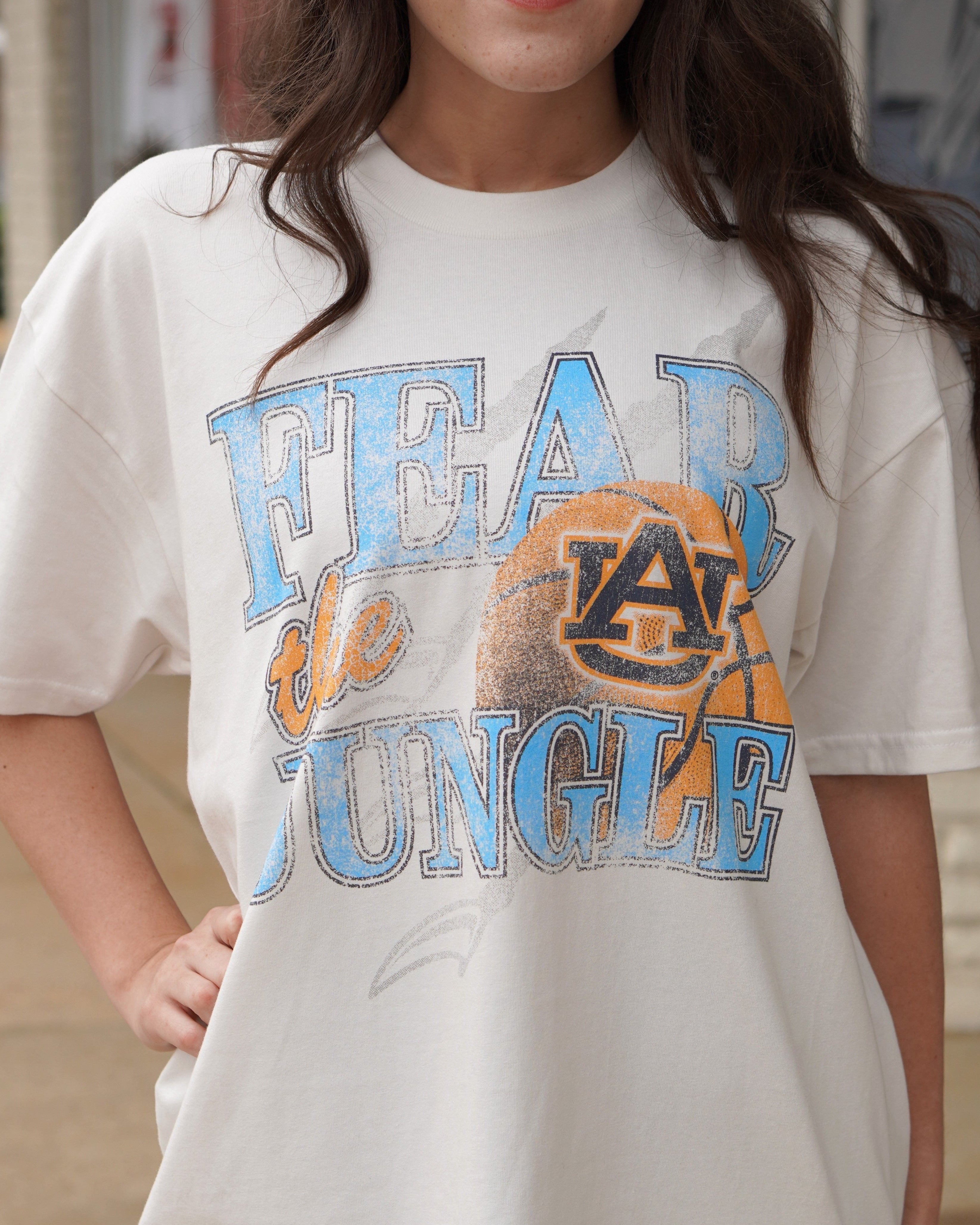 Auburn University Off-White T-Shirt with 'FEAR THE JUNGLE' text, a basketball with the AU Logo and tiger claw marks design
