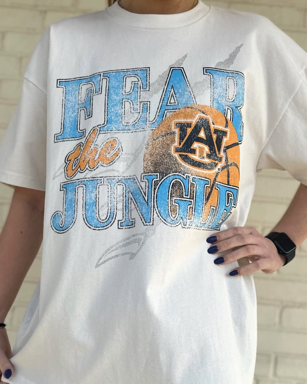 Auburn University Off-White T-Shirt with 'FEAR THE JUNGLE' text, a basketball with the AU Logo and tiger claw marks design