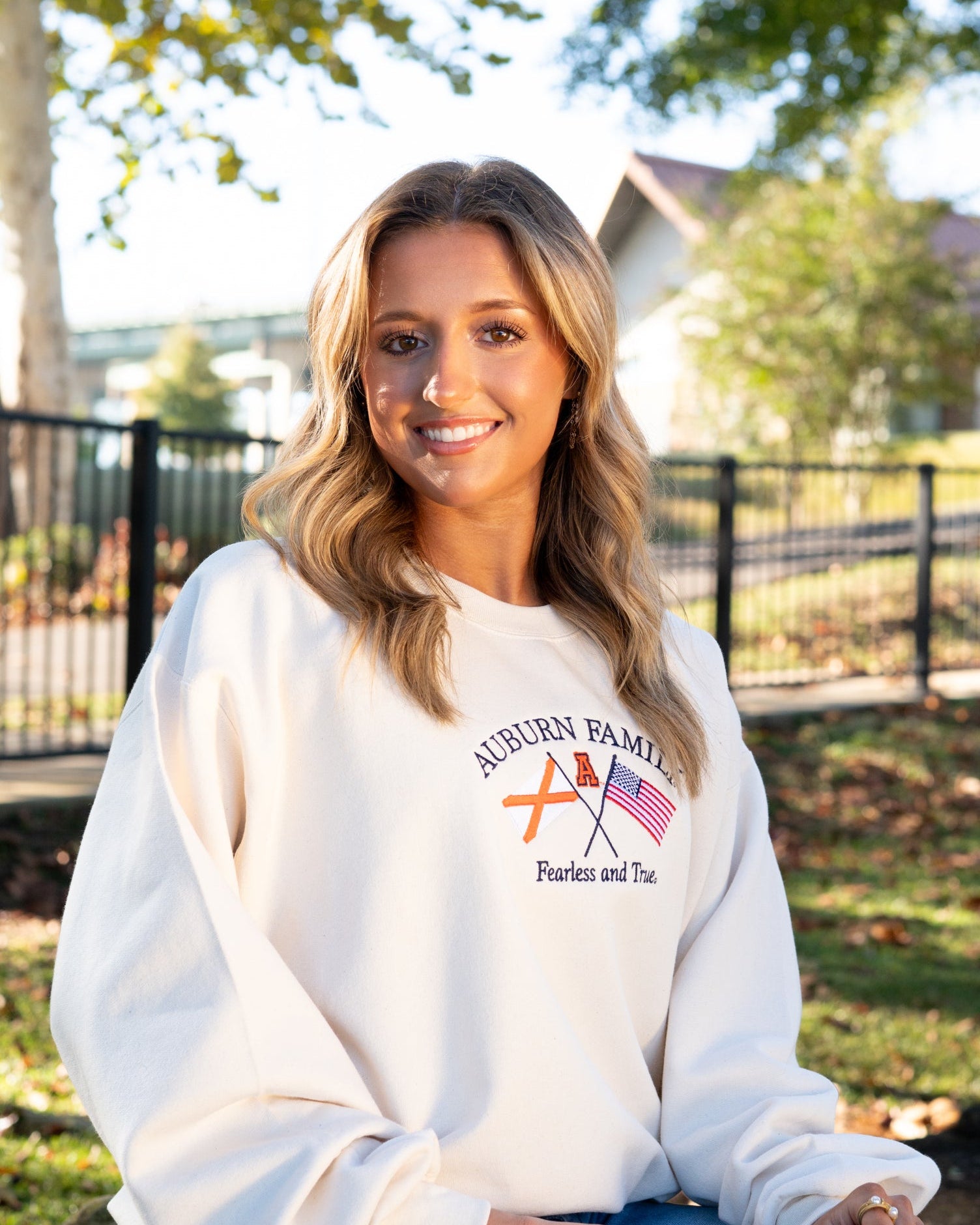 Auburn University Cream Sweatshirt with Navy text “Auburn Family” above the state flag and American flag crossed under the Block Auburn A