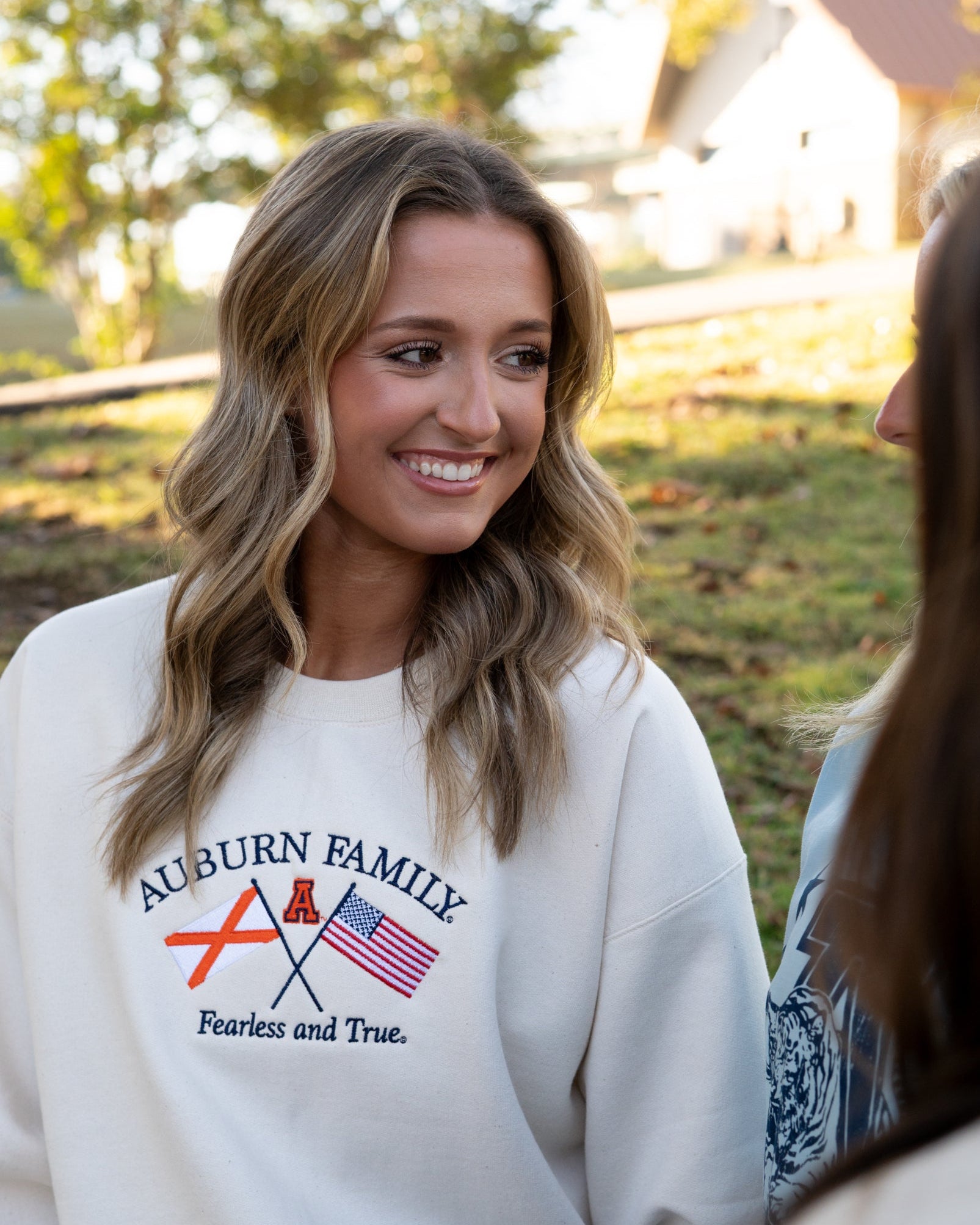 Auburn University Cream Sweatshirt with Navy text “Auburn Family” above the state flag and American flag crossed under the Block Auburn A