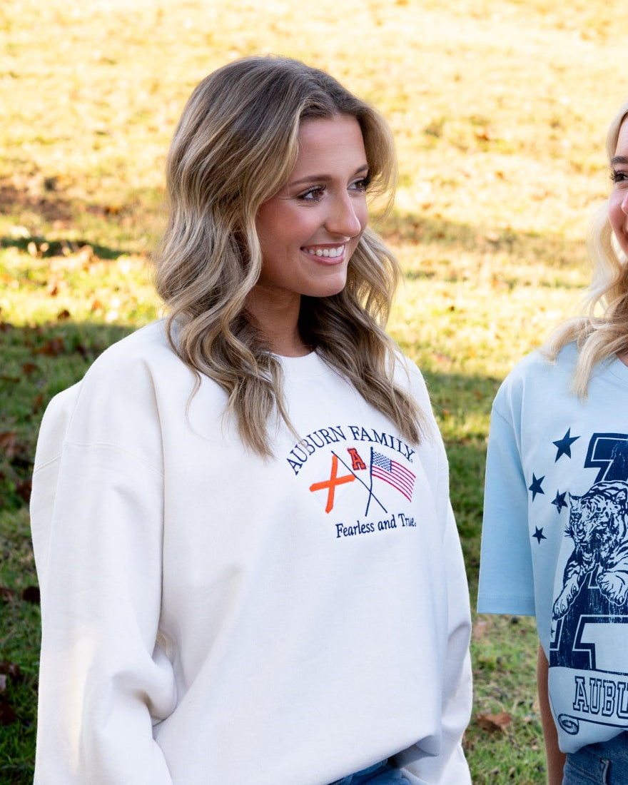 Auburn University Cream Sweatshirt with Navy text “Auburn Family” above the state flag and American flag crossed under the Block Auburn A