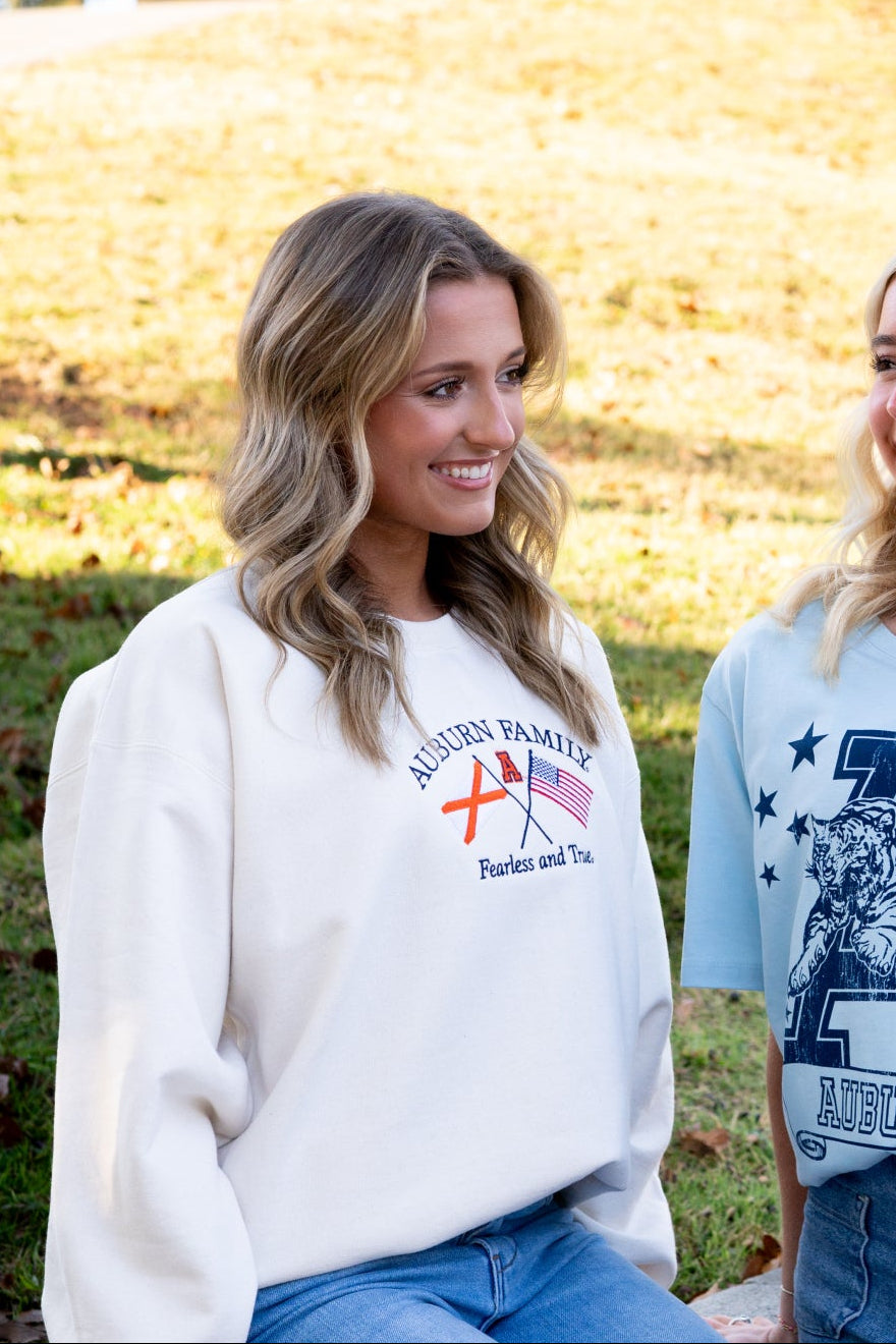 Auburn University Cream Sweatshirt with Navy text “Auburn Family” above the state flag and American flag crossed under the Block Auburn A