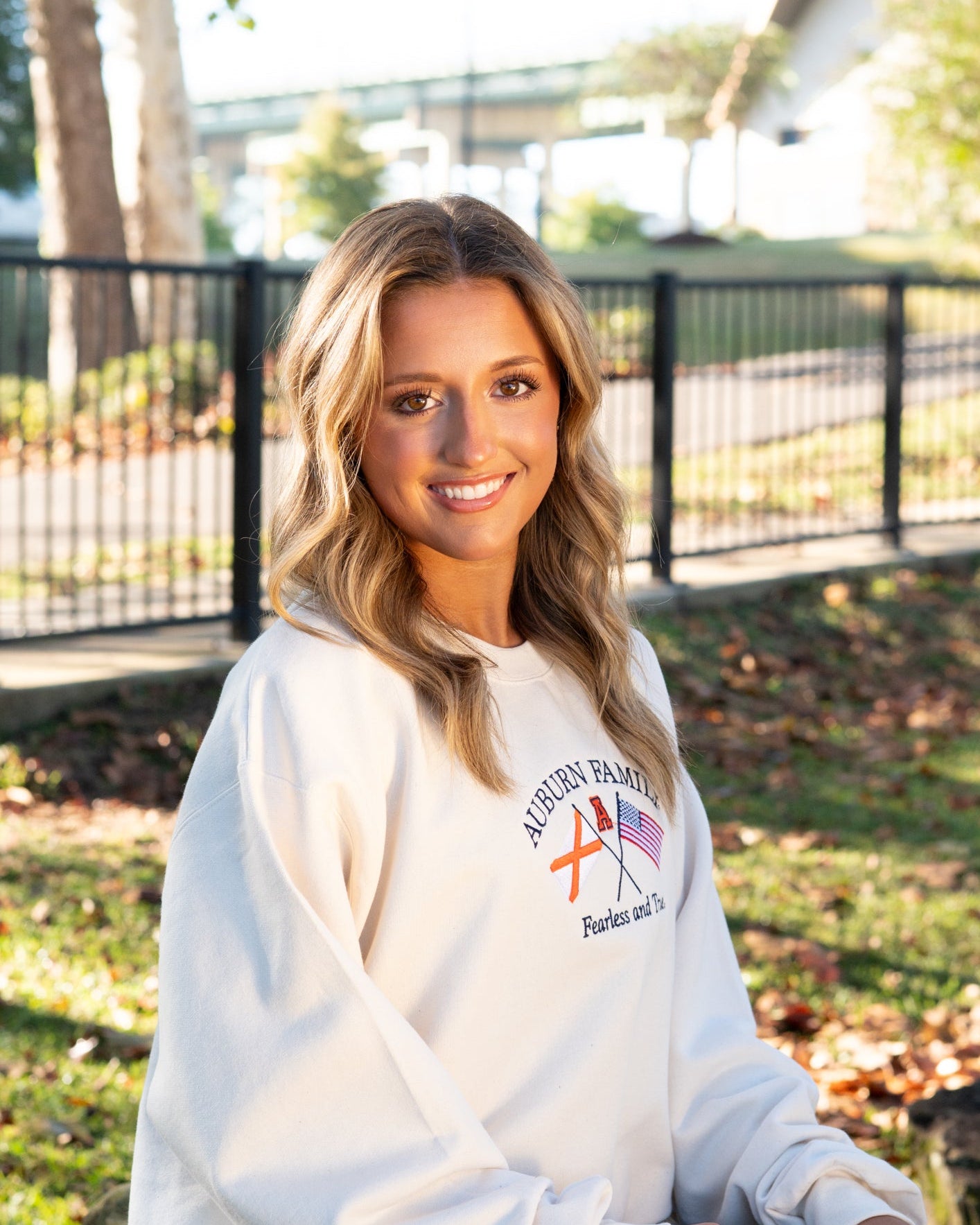 Auburn University Cream Sweatshirt with Navy text “Auburn Family” above the state flag and American flag crossed under the Block Auburn A