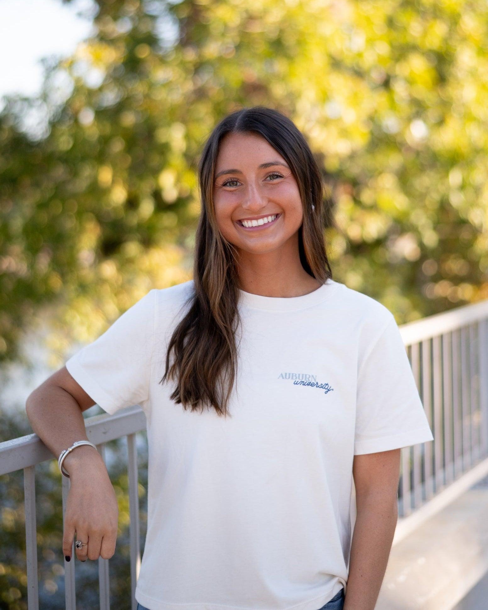 Auburn University White Ladies Tee with a vintage Blue illustration of cowgirl boots with bows tied on them above Blue text “Home On The Plains”