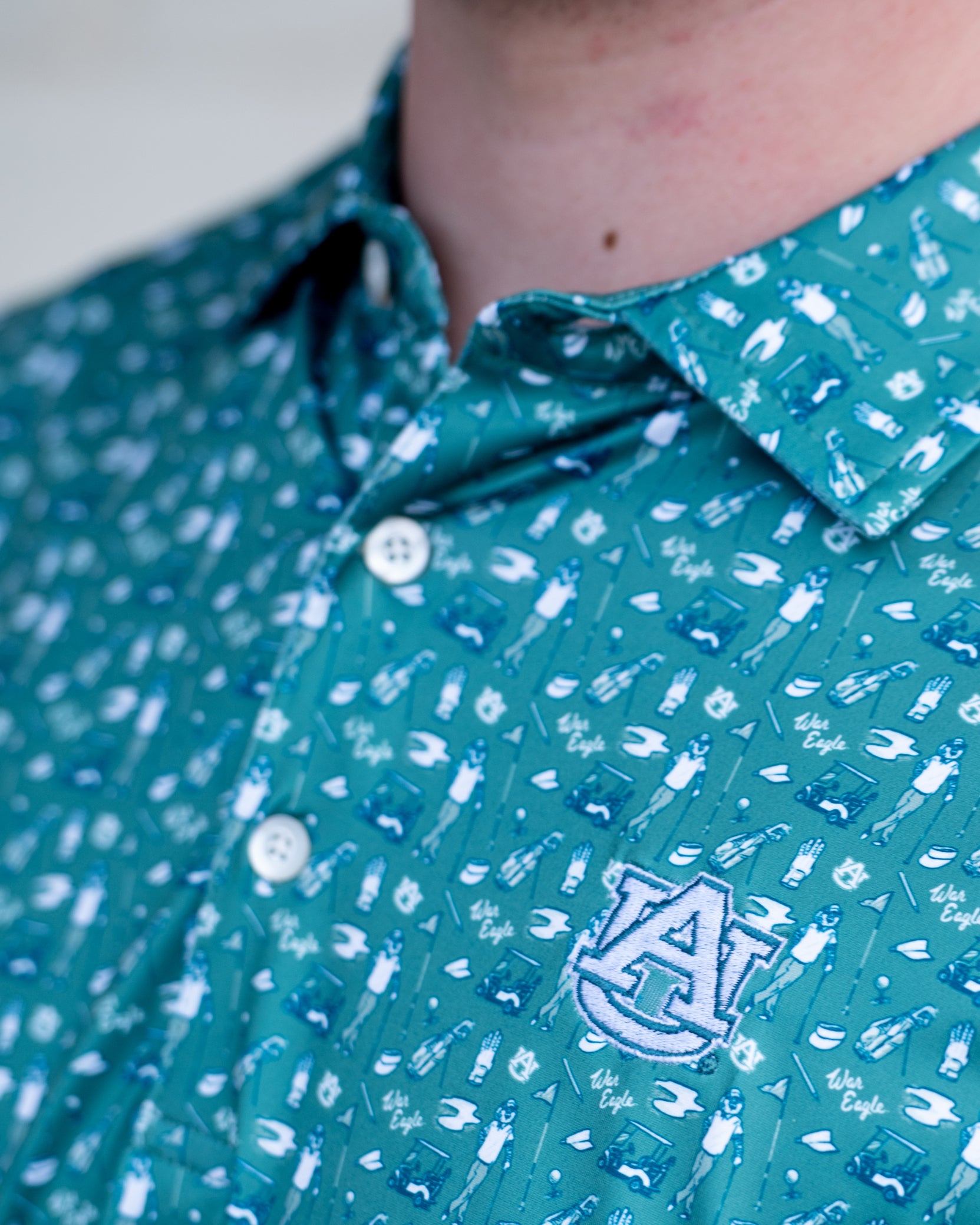 Auburn University Green Men’s Polo with an Auburn golf-themed pattern and Silver AU Logo embroidery