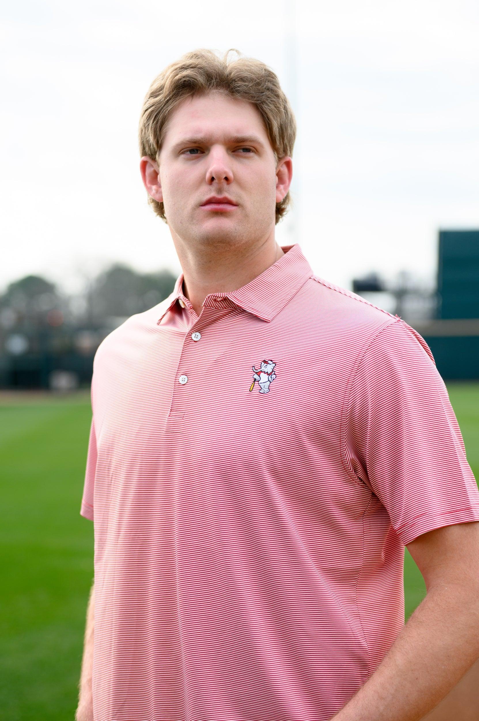 University of Alabama Men's Crimson Stripe Performance Polo with an embroidered image of Big Al in a baseball uniform leaning on a baseball bat