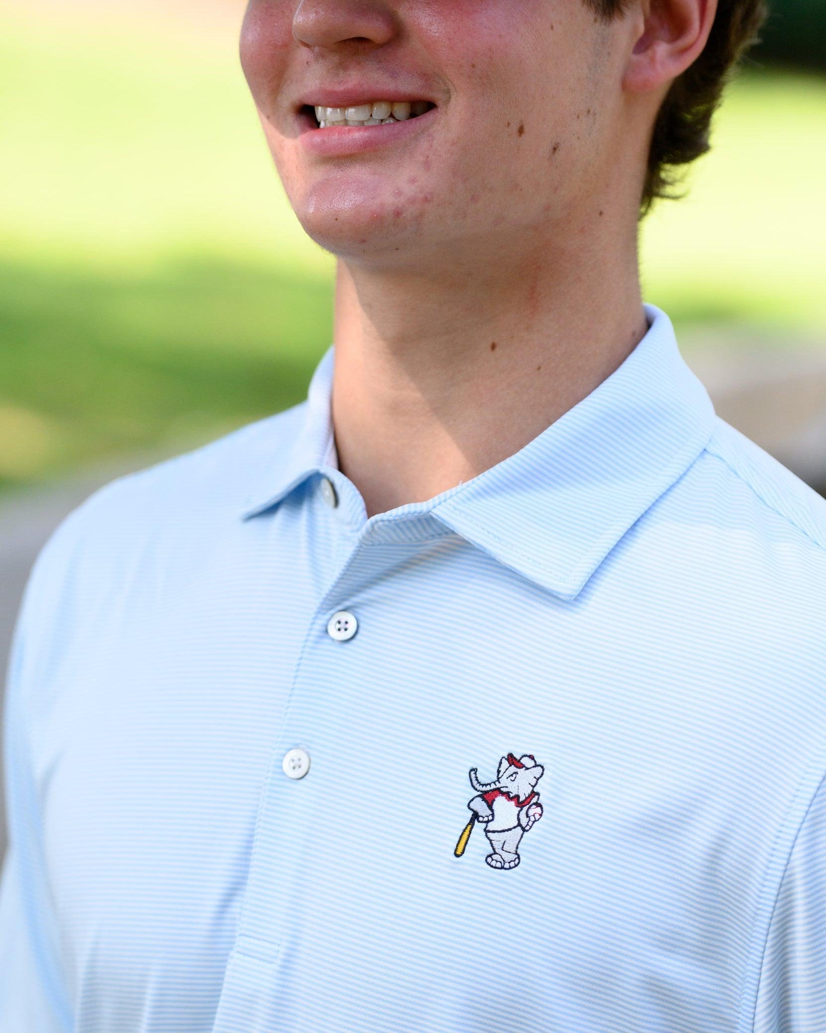 University of Alabama BallPlayer Al Men's Light Blue Performance Polo with an embroidered image of Big Al in a baseball uniform leaning on a baseball bat