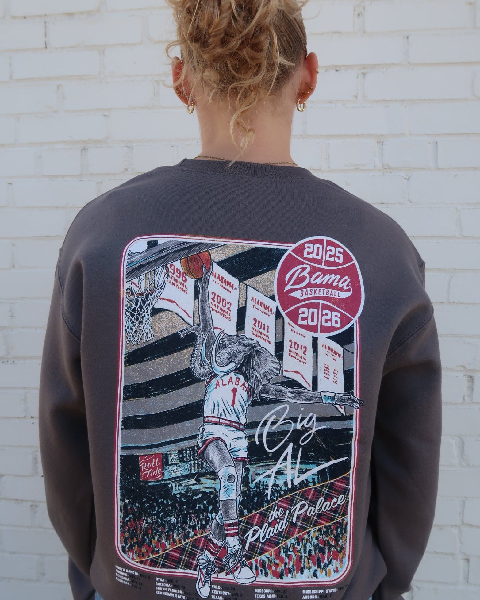 University of Alabama Dark Grey Sweatshirt with an illustration of Big Al dunking a basketball next to text “Big Al” and “the Plaid Palace” above the 2025 Basketball Schedule