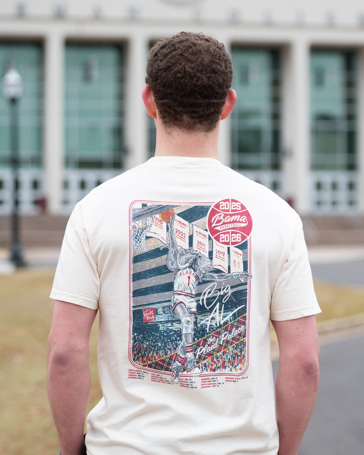 University of Alabama Ivory Shirt with an illustration of Big Al dunking a basketball next to text “Big Al” and “the Plaid Palace” above the 2025 Basketball Schedule