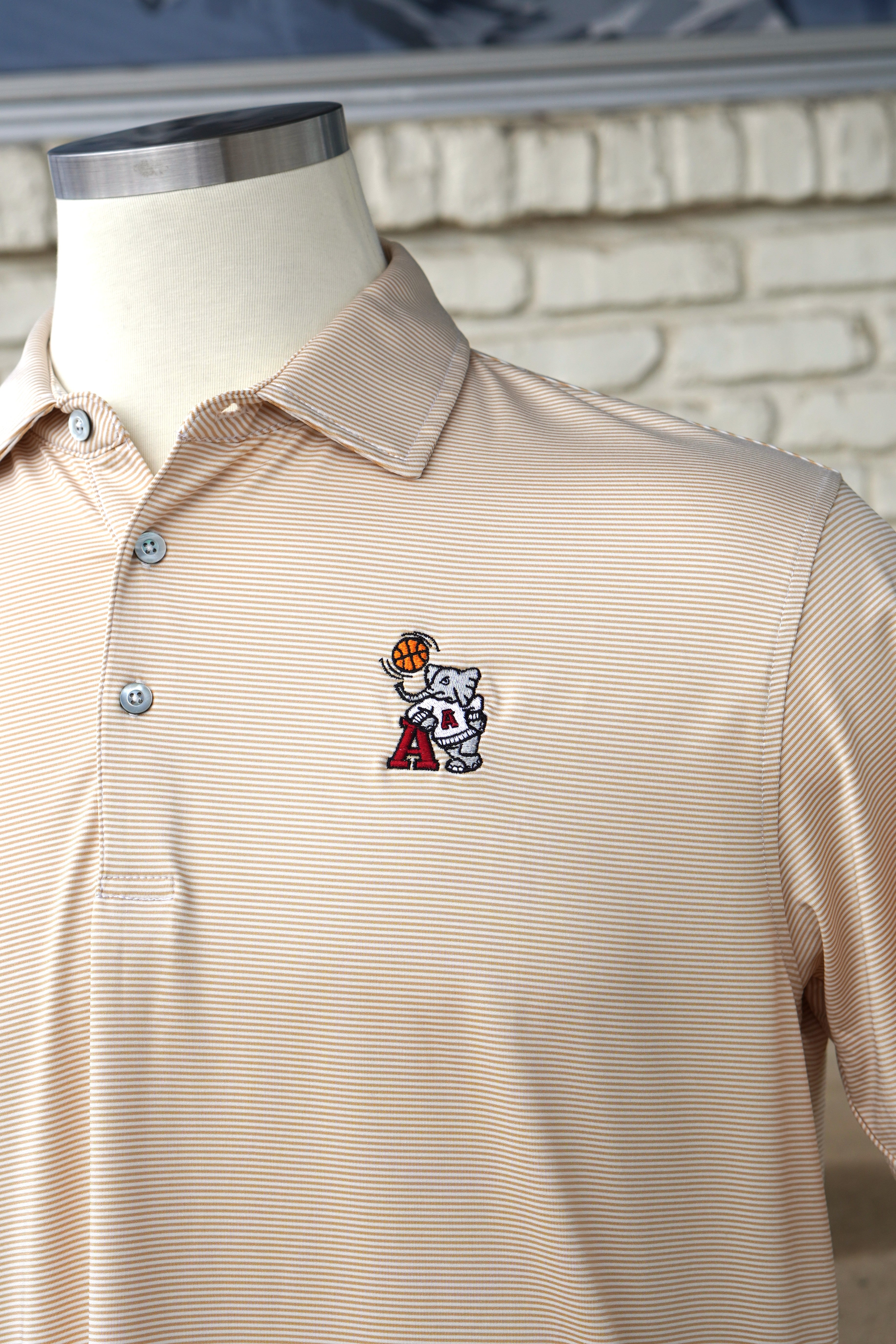University of Alabama Basketball Al Tan Men’s Polo with an embroidered Big Al in a sweater holding a basketball and leaning against an "A"