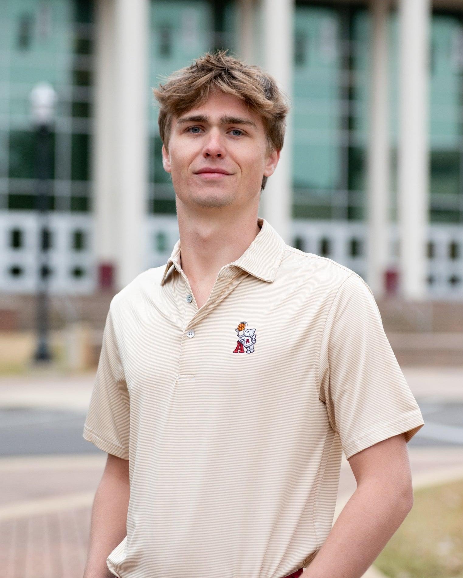 University of Alabama Basketball Al Tan Men’s Polo with an embroidered Big Al in a sweater holding a basketball and leaning against an "A"