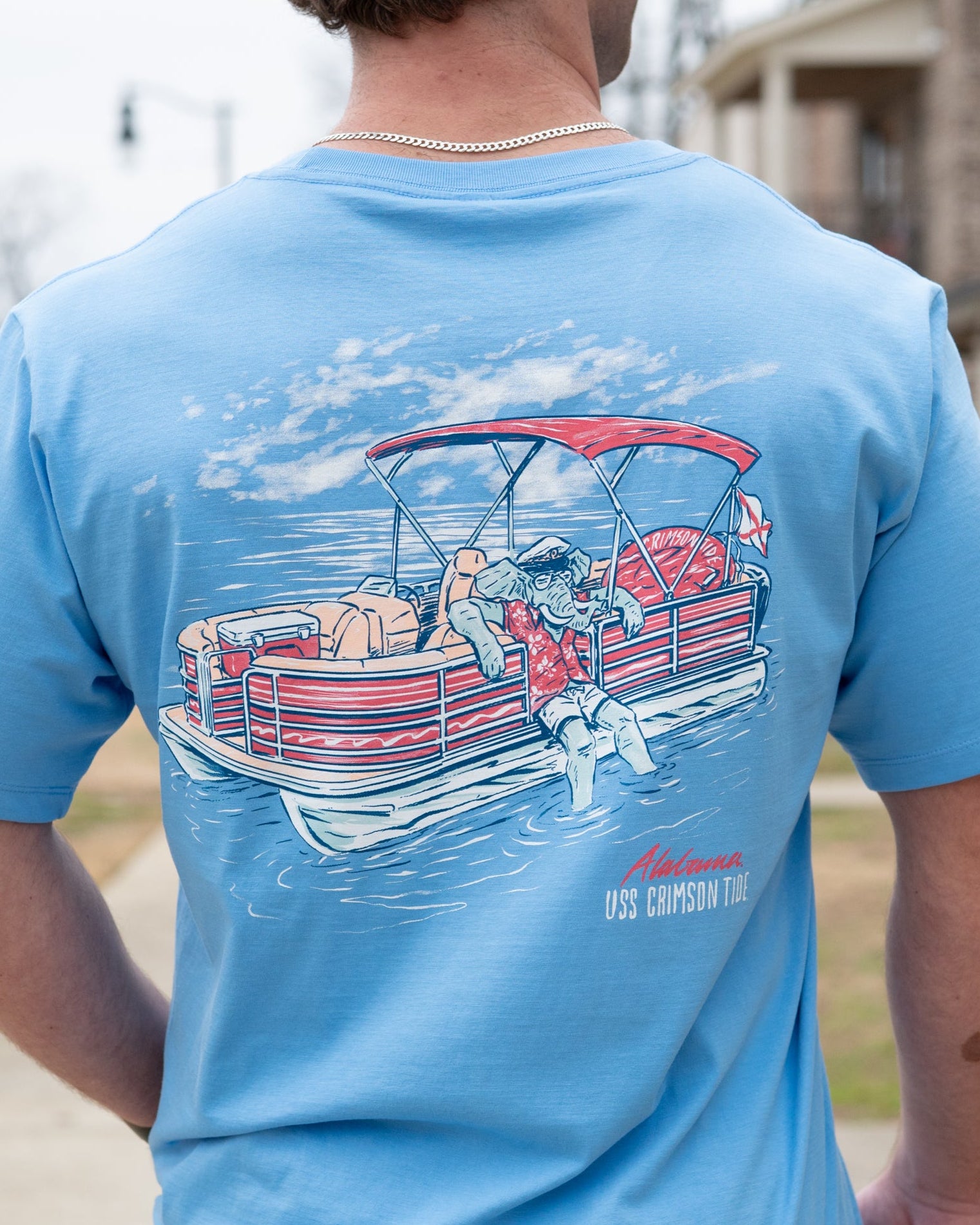 University of Alabama Big Al Pontoon Azure Comfort Colors T-Shirt with an image of Big Al lounging on the side of a Red and White Pontoon Boat with the text "USS Crimson Tide" below