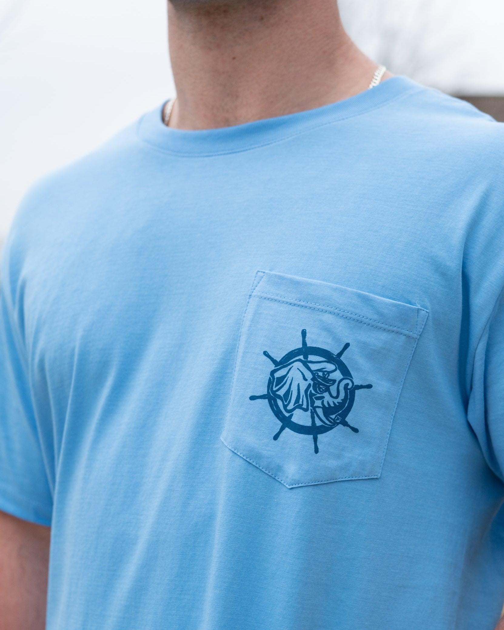 University of Alabama Blue Shirt with a front pocket featuring a ship’s wheel behind a Sailor Big Al design