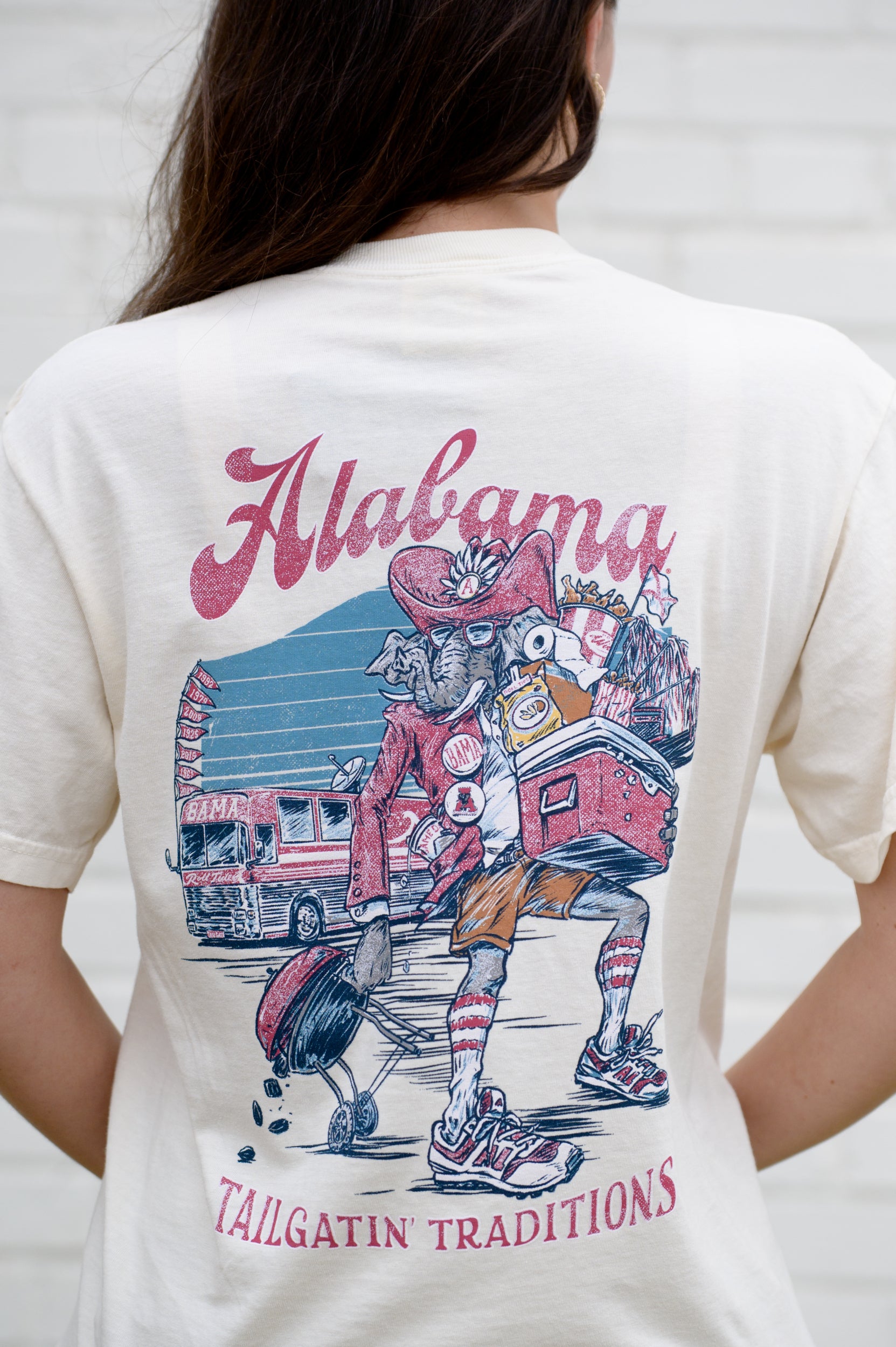 University of Alabama Cream Big Al Tailgate Comfort Colors T-Shirt with an image of Big Al in Gameday Gear with a cooler and a grill above text "Tailgatin' Traditions"