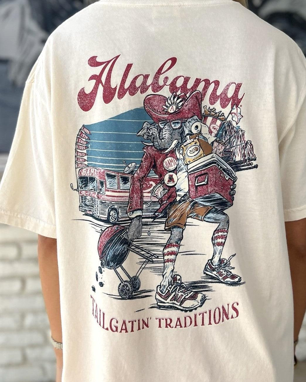 University of Alabama Cream Big Al Tailgate Comfort Colors T-Shirt with an image of Big Al in Gameday Gear with a cooler and a grill above text "Tailgatin' Traditions"