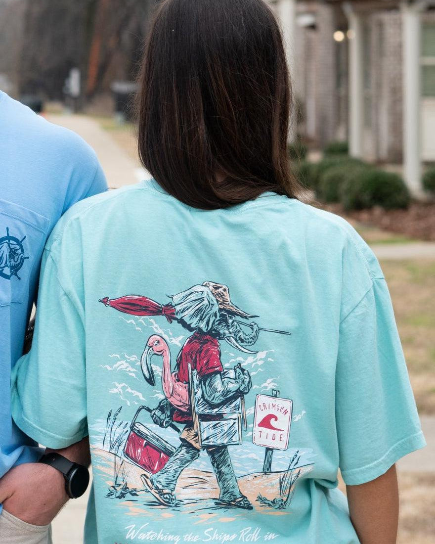 University of Alabama Mint T-Shirt with an image of Big Al in beach clothes carrying an umbrella dragging a cooler across the sand