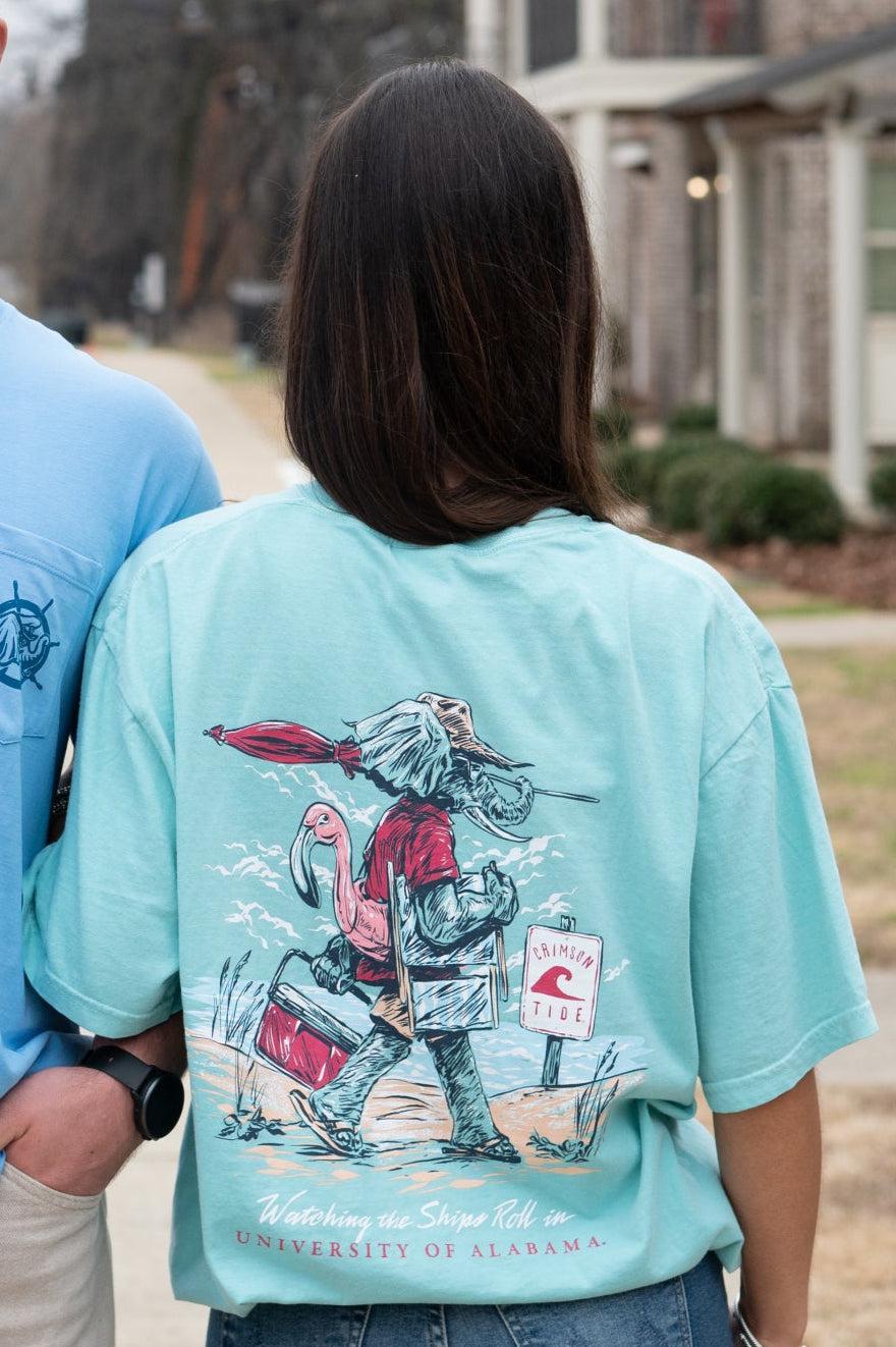 University of Alabama Mint T-Shirt with an image of Big Al in beach clothes carrying an umbrella dragging a cooler across the sand