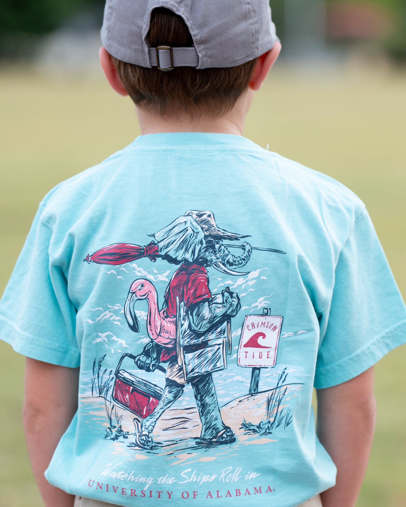 University of Alabama Big Al Beach Chalky Mint Comfort Colors Youth T-Shirt with an image of Big Al in beach clothes carrying an umbrella dragging a cooler across the sand