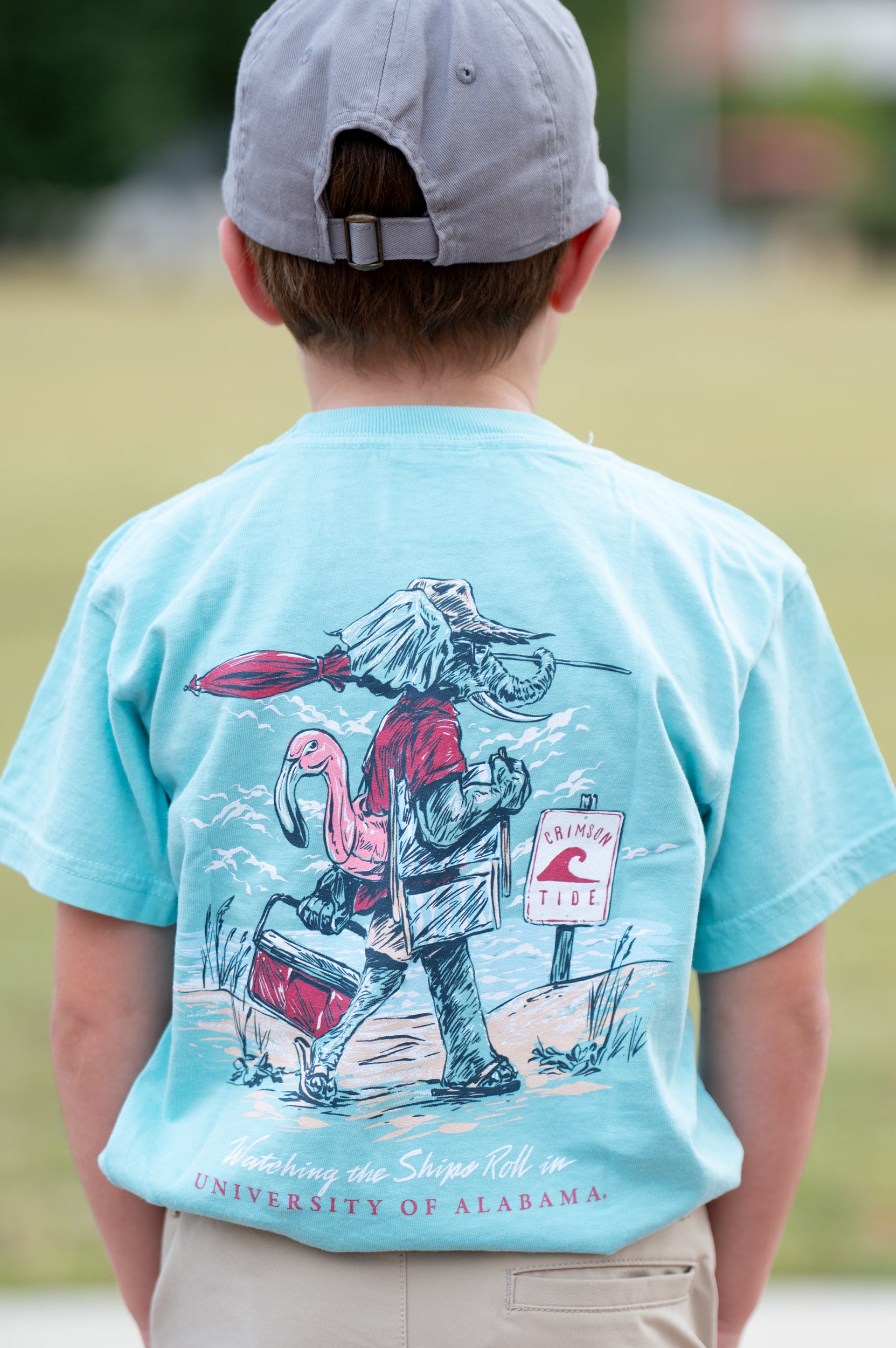 University of Alabama Big Al Beach Chalky Mint Comfort Colors Youth T-Shirt with an image of Big Al in beach clothes carrying an umbrella dragging a cooler across the sand