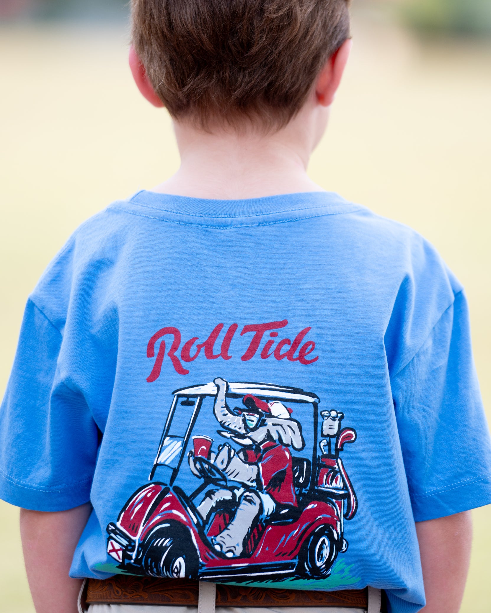 University of Alabama Big Al Golf Cart Blue SoftShirts Youth Tee with the text "Roll Tide" above an image of Big Al wearing sunglasses and driving a golf cart