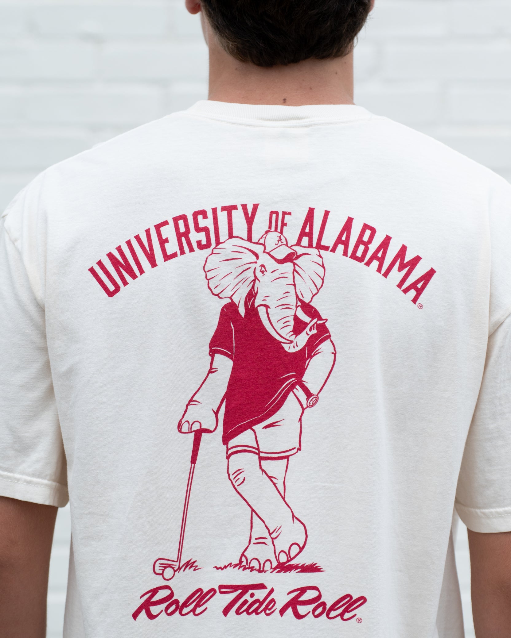 University of Alabama Ivory T-Shirt with an image of Big Al leaning against a golf club between Red Text "University of Alabama" and "Roll Tide Roll"