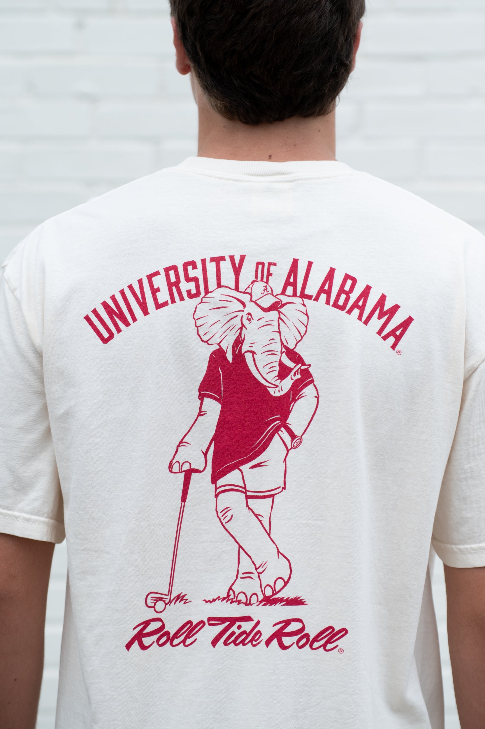 University of Alabama Ivory T-Shirt with an image of Big Al leaning against a golf club between Red Text "University of Alabama" and "Roll Tide Roll"