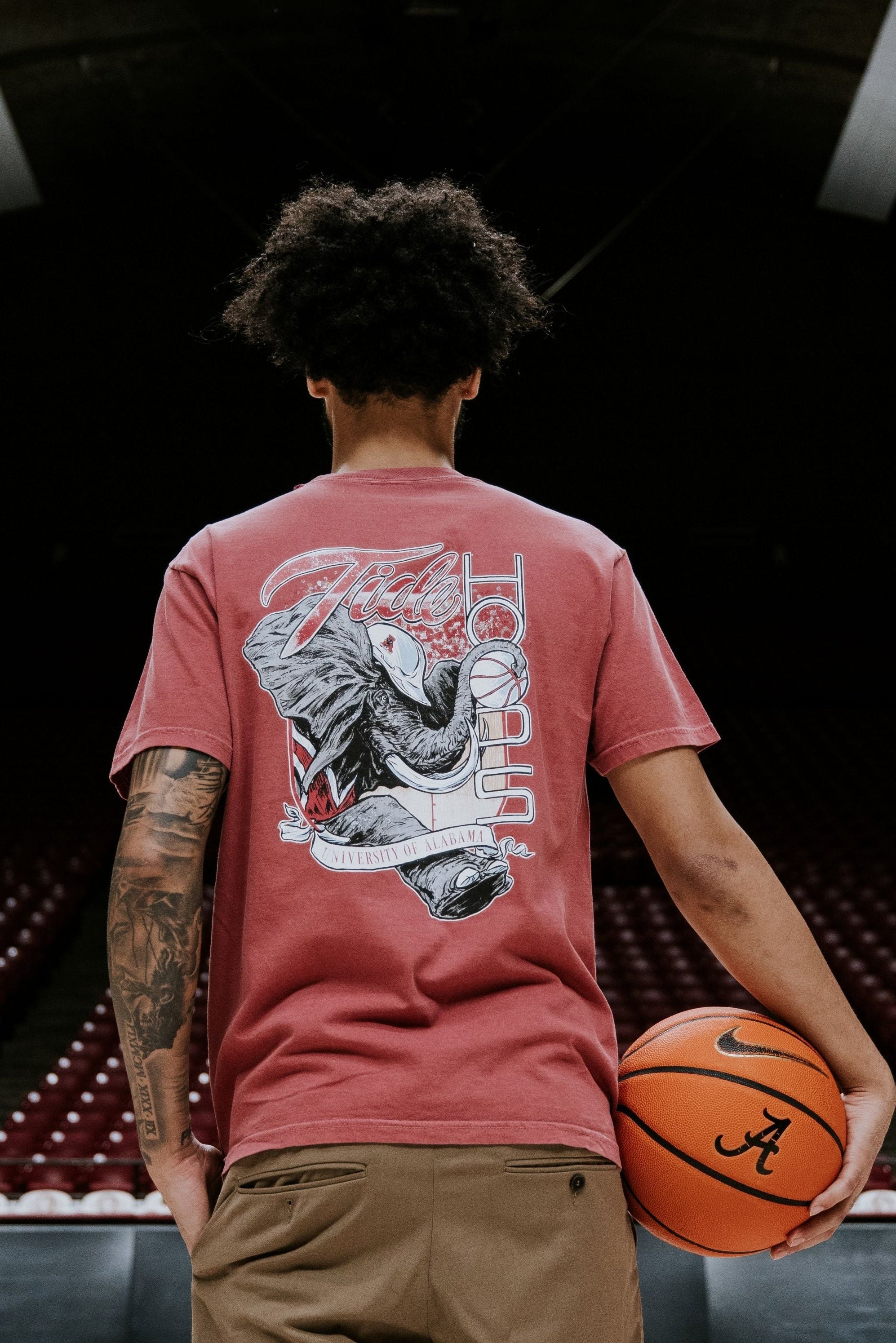 University of Alabama Red T-Shirt with Big Al wearing a hard hat and holding a basketball with his trunk to help spell the word “Hoops”