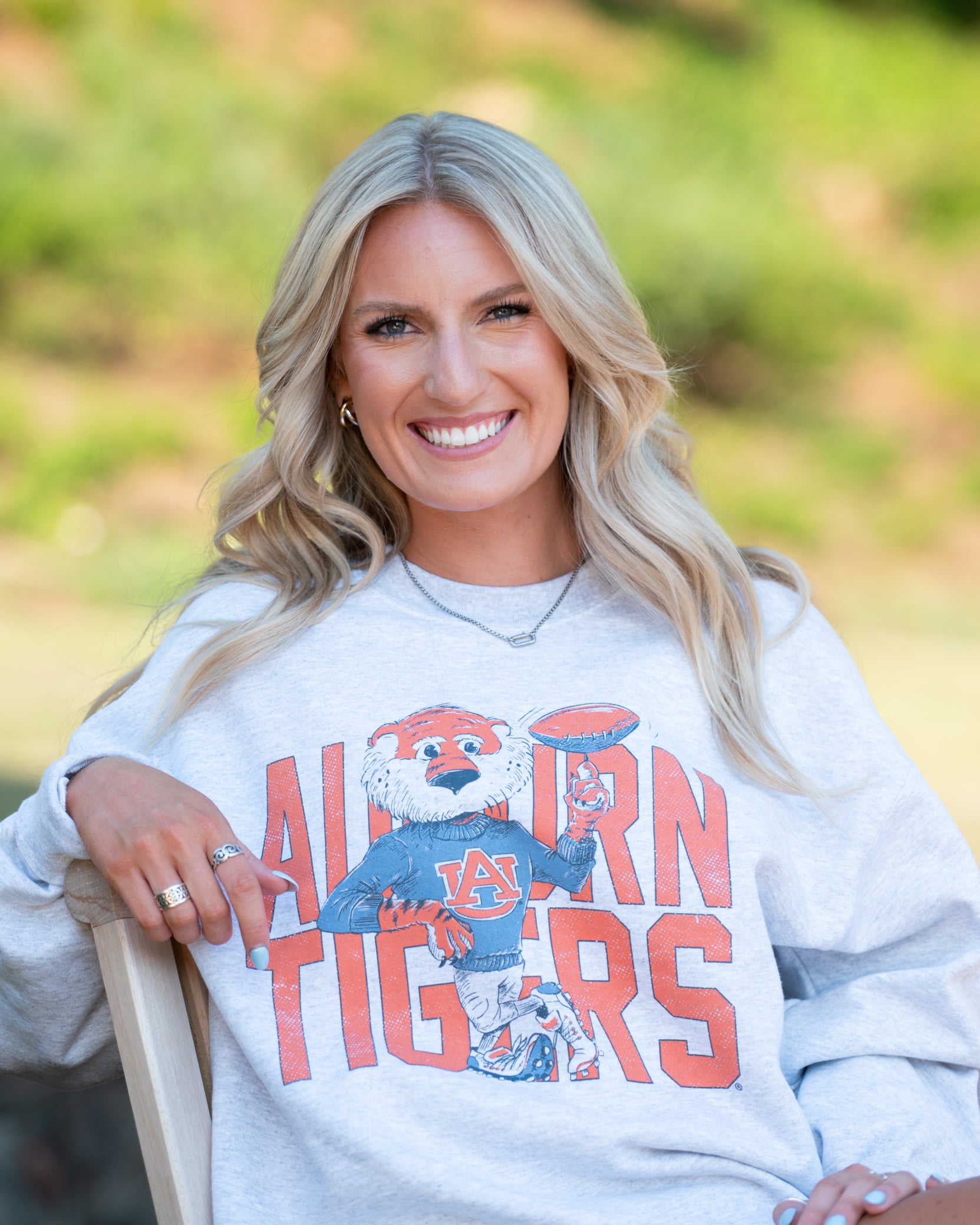 Auburn University Grey Chill Aubie Sweatshirt with Orange text "Auburn Tigers” and a graphic of Aubie leaning against the "G" of "Tigers"