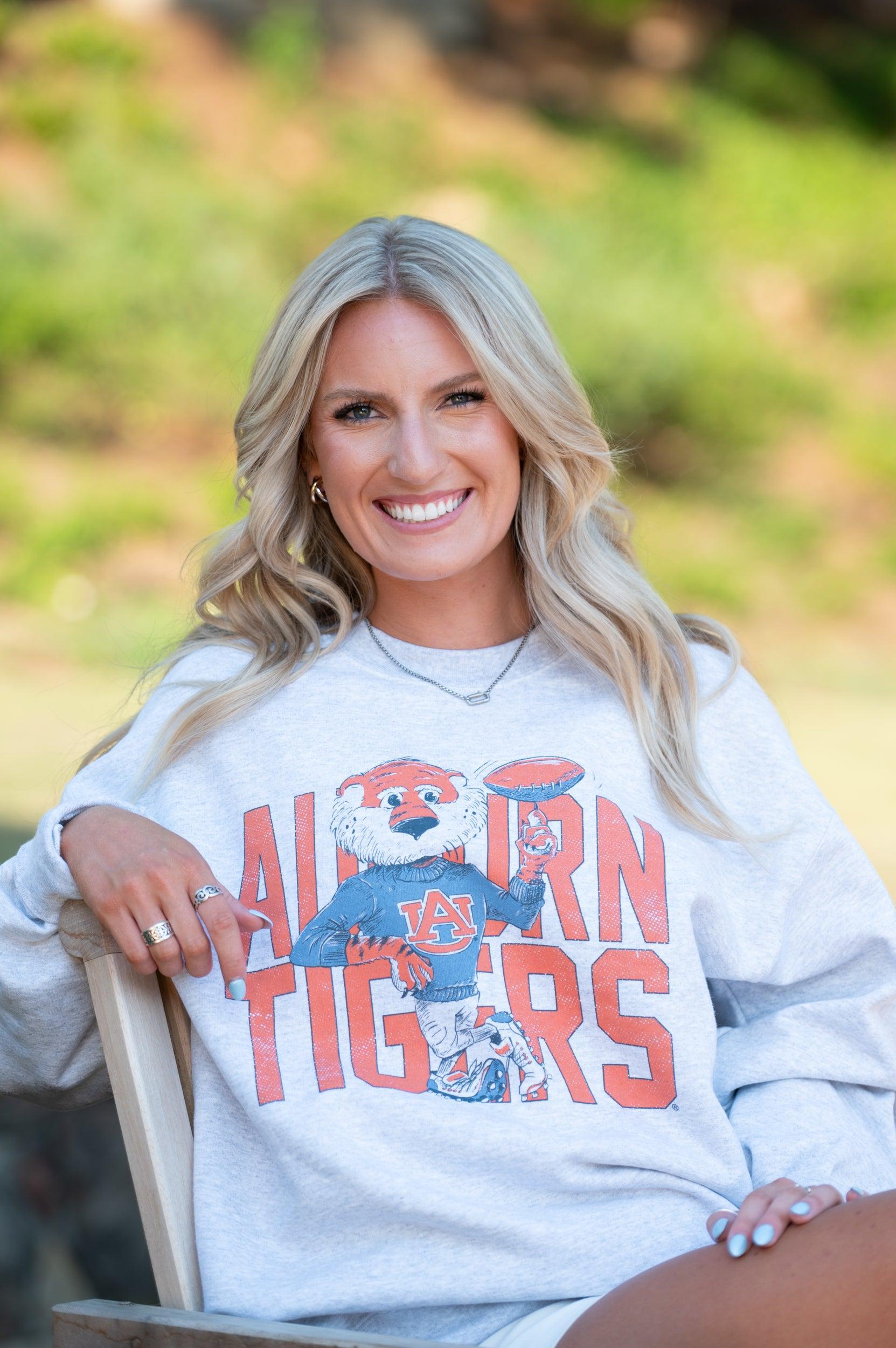 Auburn University Grey Chill Aubie Sweatshirt with Orange text "Auburn Tigers” and a graphic of Aubie leaning against the "G" of "Tigers"
