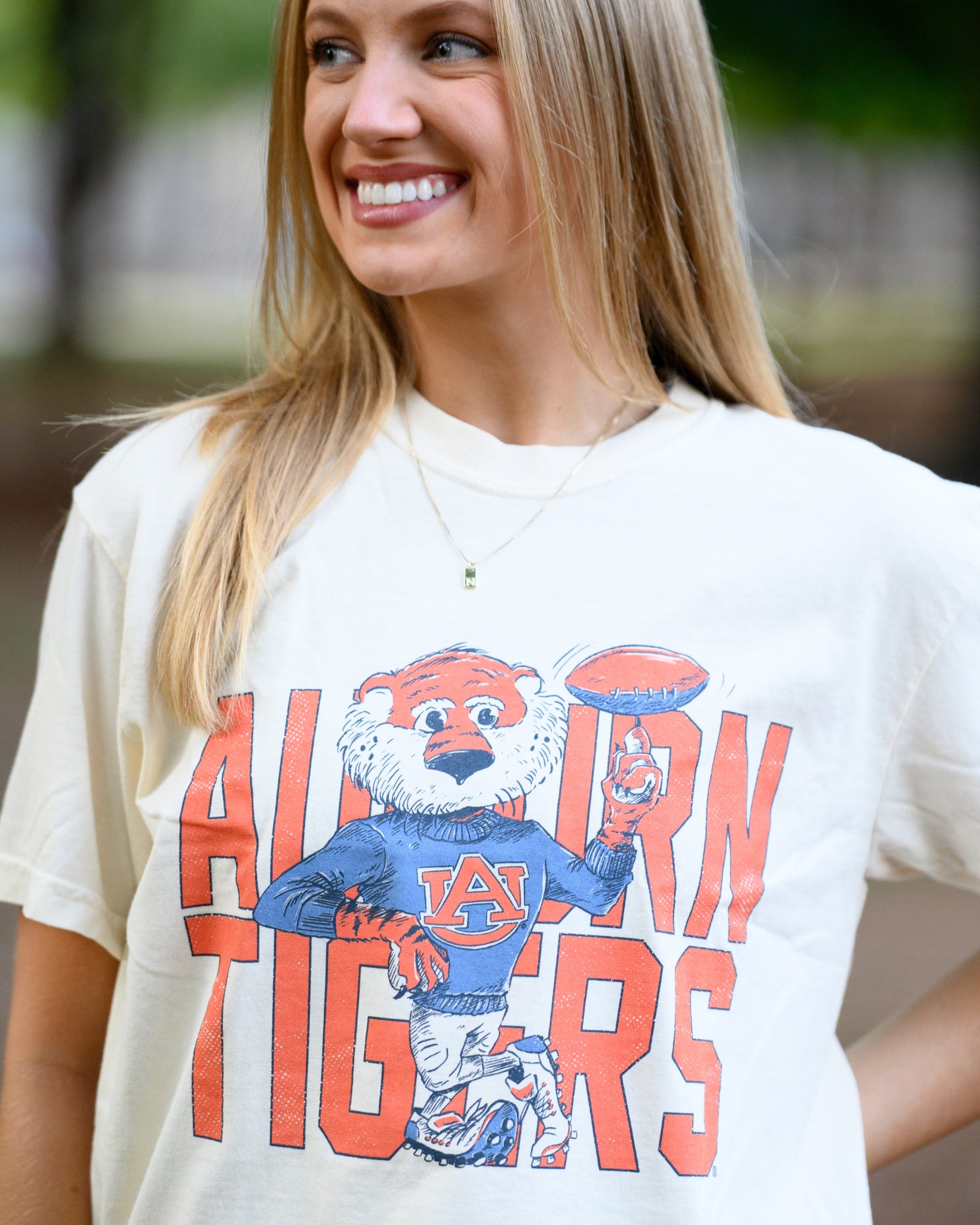 Auburn University Cream Chill Aubie Comfort Colors T-Shirt with Orange text "Auburn Tigers" and a graphic of Aubie leaning against the "G" of "Tigers"