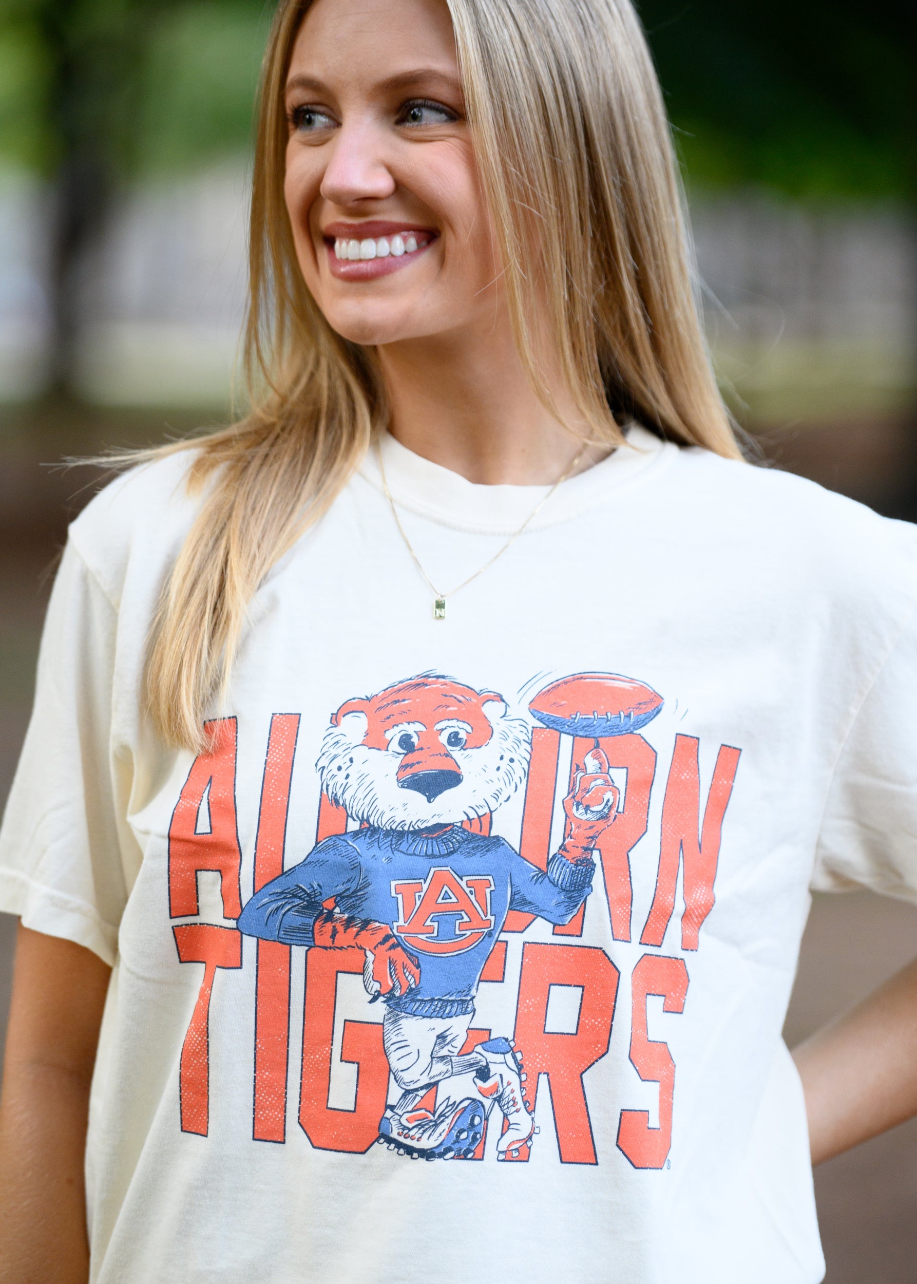Auburn University Cream Chill Aubie Comfort Colors T-Shirt with Orange text "Auburn Tigers" and a graphic of Aubie leaning against the "G" of "Tigers"