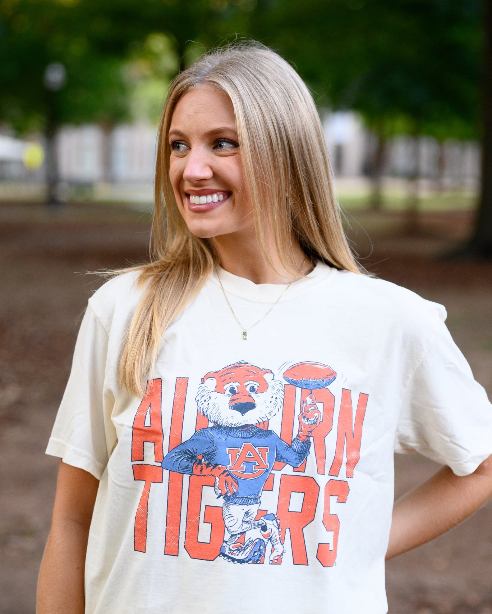 Auburn University Cream Chill Aubie Comfort Colors T-Shirt with Orange text "Auburn Tigers" and a graphic of Aubie leaning against the "G" of "Tigers"