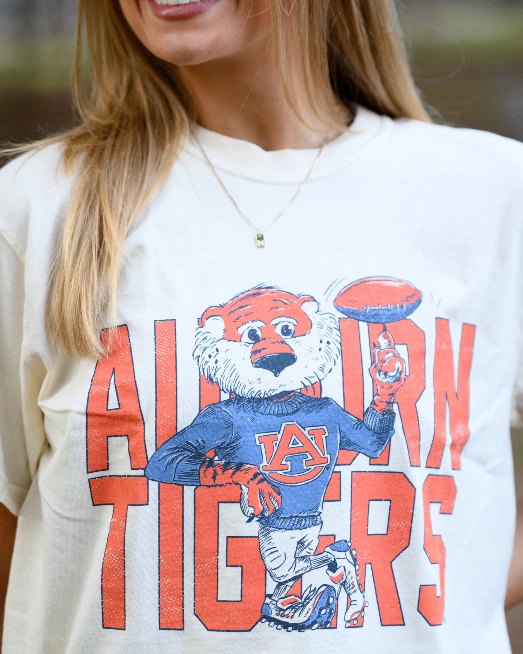 Auburn University Cream Chill Aubie Comfort Colors T-Shirt with Orange text "Auburn Tigers" and a graphic of Aubie leaning against the "G" of "Tigers"