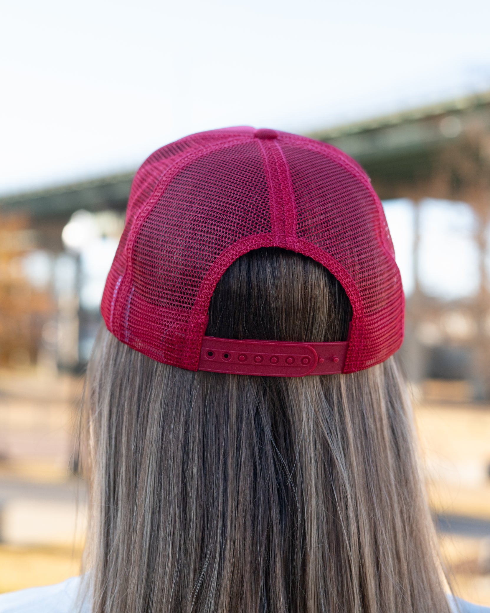 University of Alabama Red Trucker Hat with a patch featuring text “Dixieland” above and “Delight” below drawings of a cowboy boot, money, drink can, football, and playing card