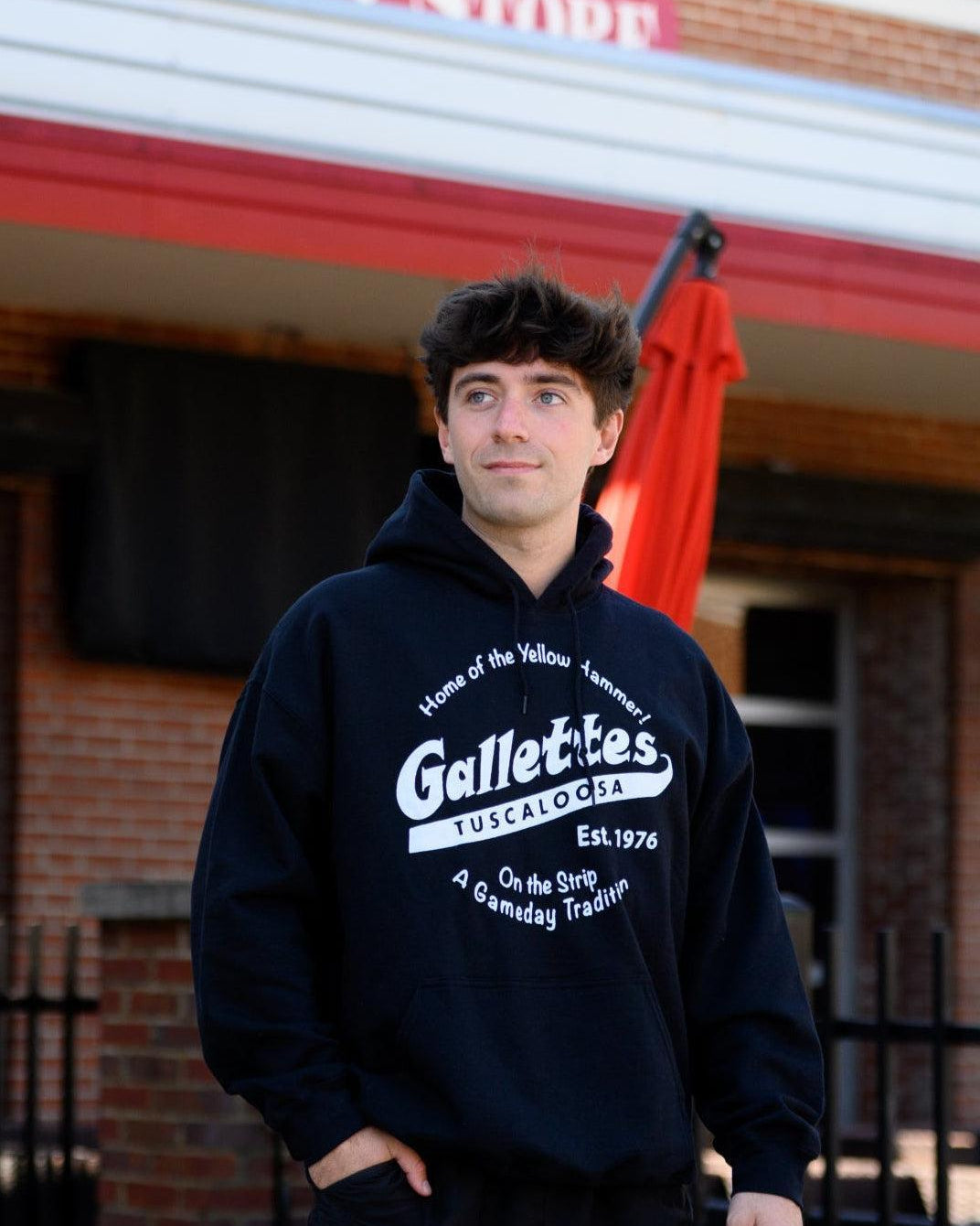 Gallettes Black Hoodie with a White Gallettes logo surrounded by White text "Home of the Yellow Hammer!" and "On the Strip- A Gameday Tradition"